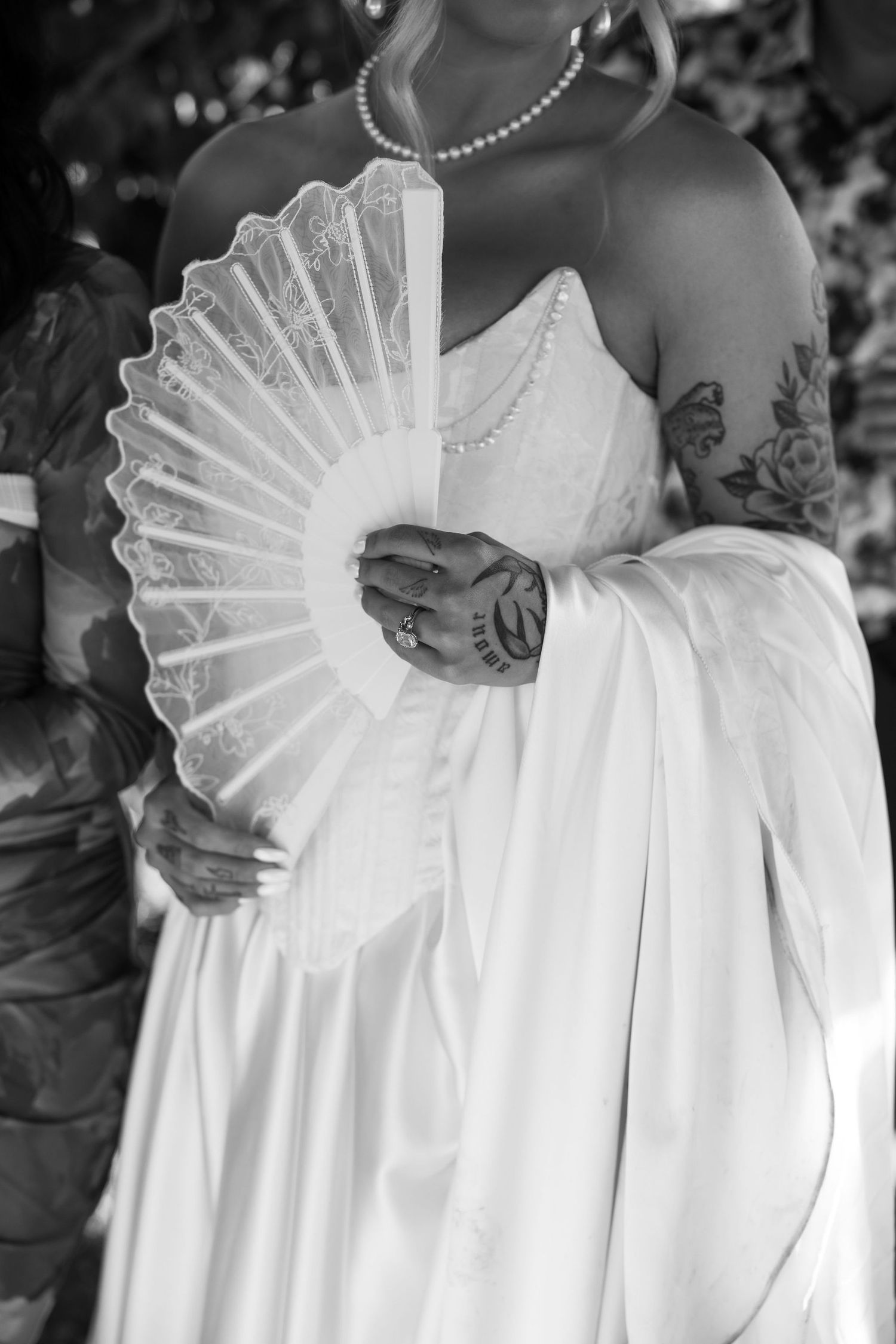 Series of black and white photos showing details of a white wedding dress with pleated fabric.