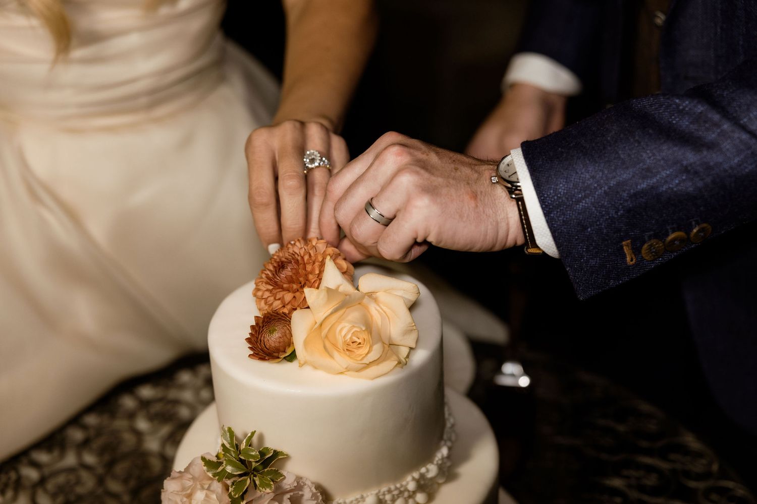 A person's hand scoops a spoonful of creamy dessert from an elegant white ceramic bowl at a restaurant table.
