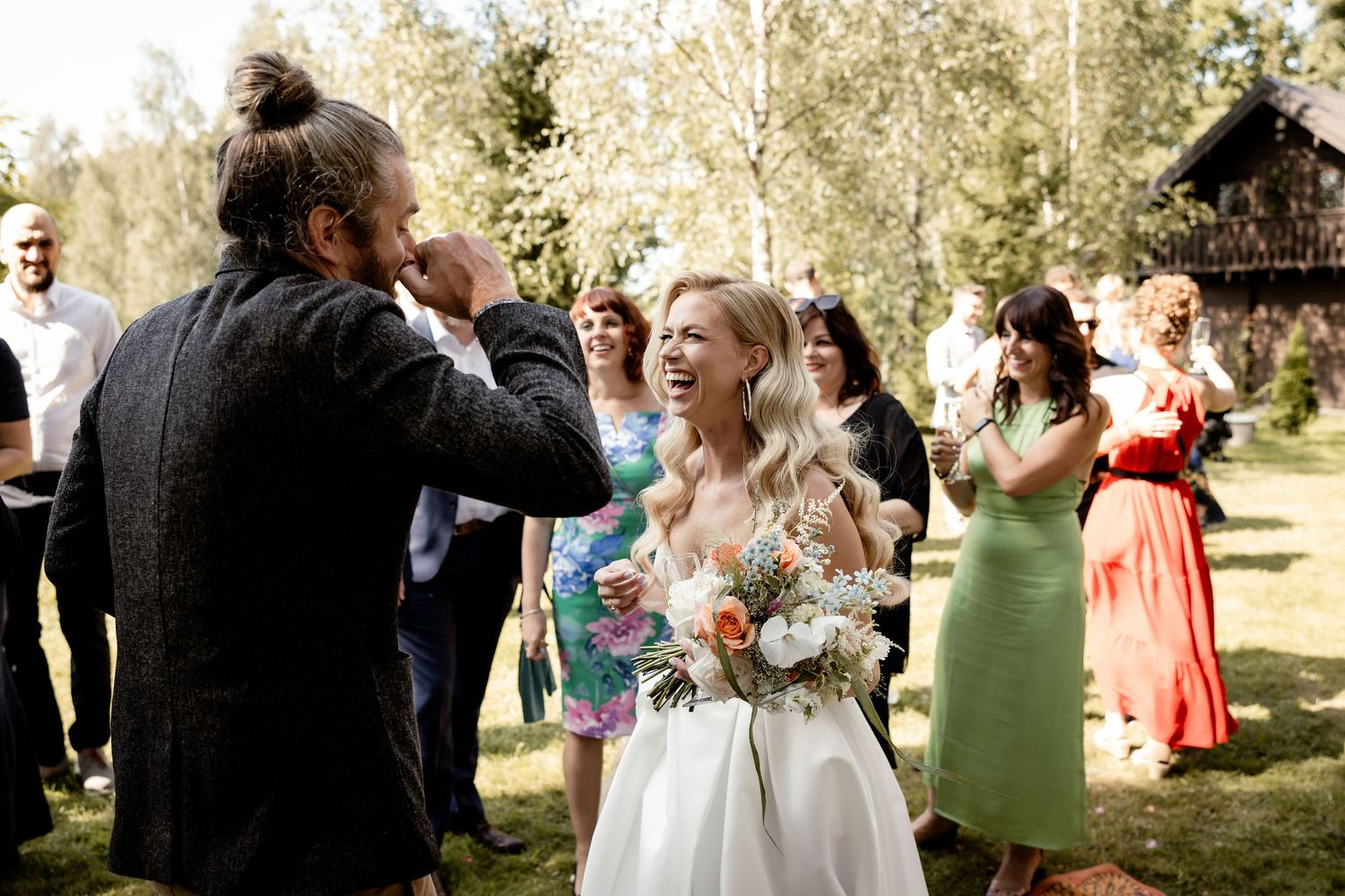 Candid celebration moment during outdoor woodland wedding reception.