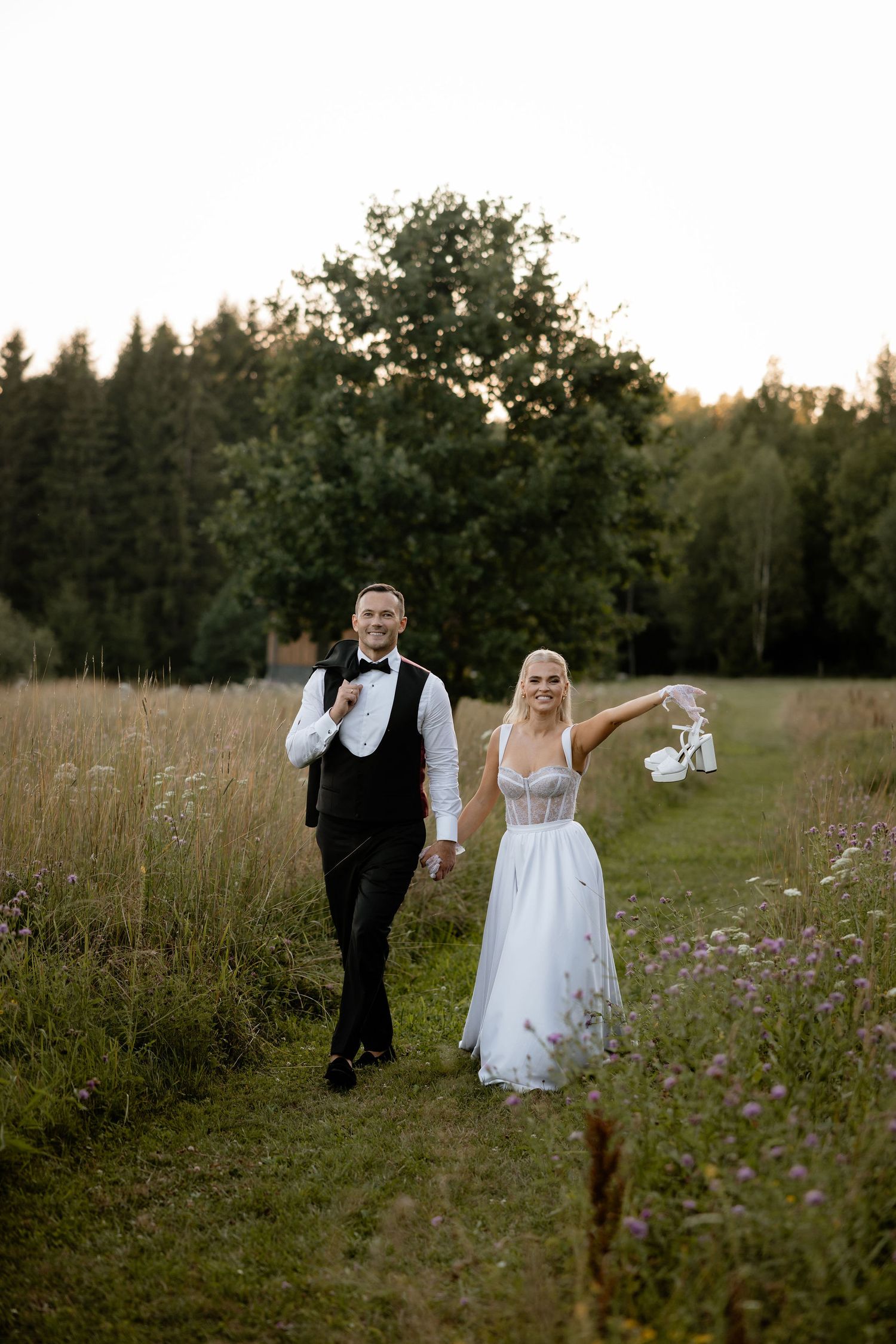 A romantic sunset kiss between newlyweds in a wildflower meadow.