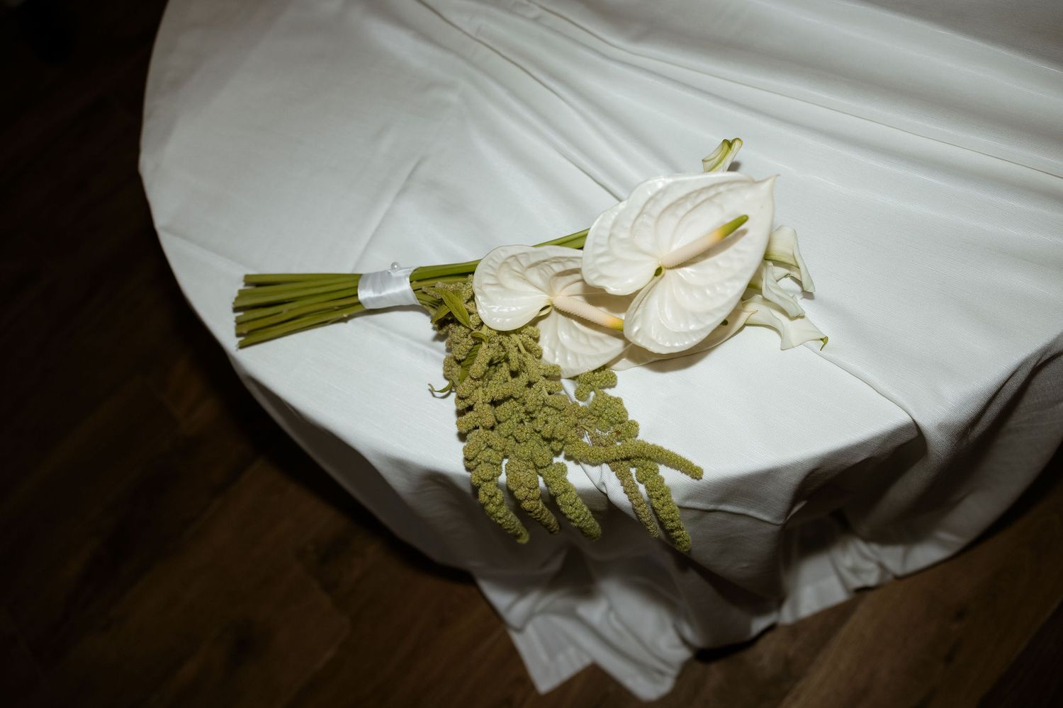 Wedding dress details and accessories laid out on white fabric in preparation for the ceremony.