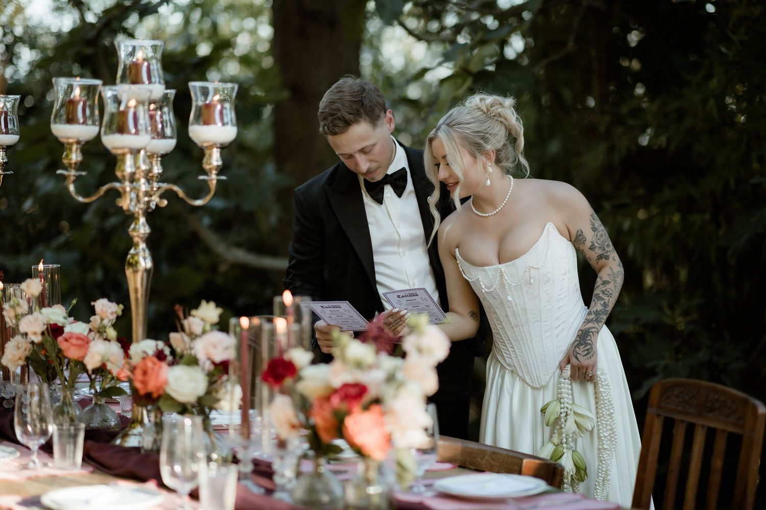 A romantic wedding reception table decorated with elegant candelabras and floral arrangements in a garden setting.