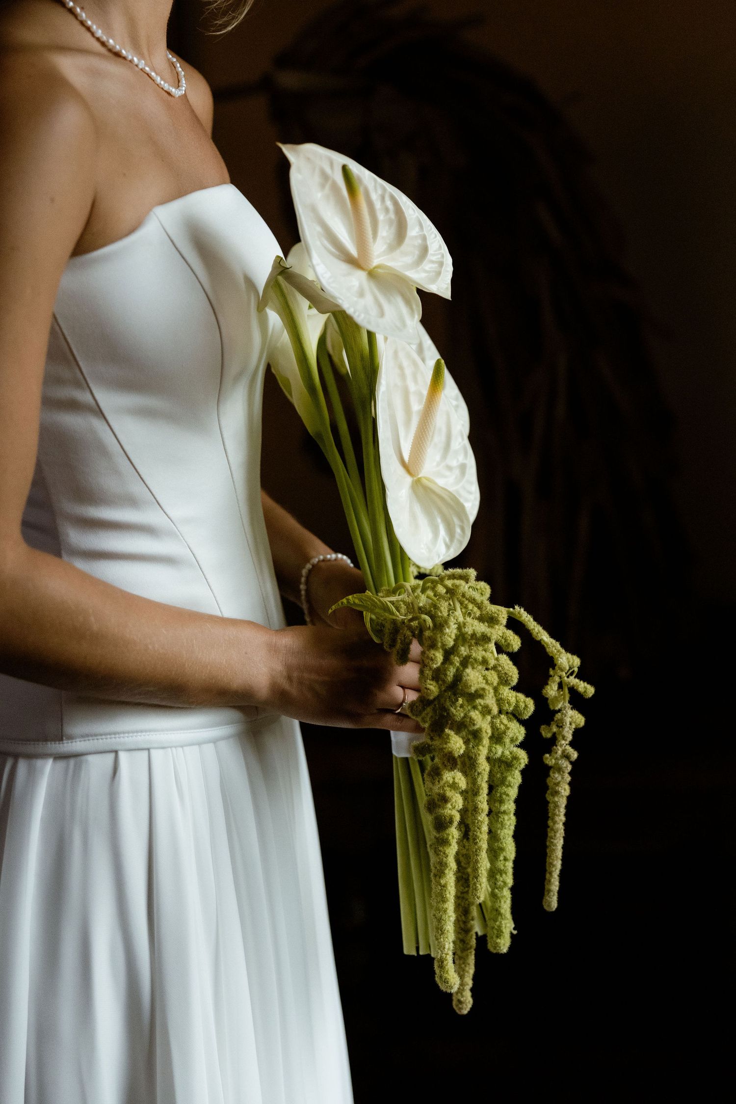 A series of elegant white dress photos with calla lilies and amaranthus bouquet details against a dark background.