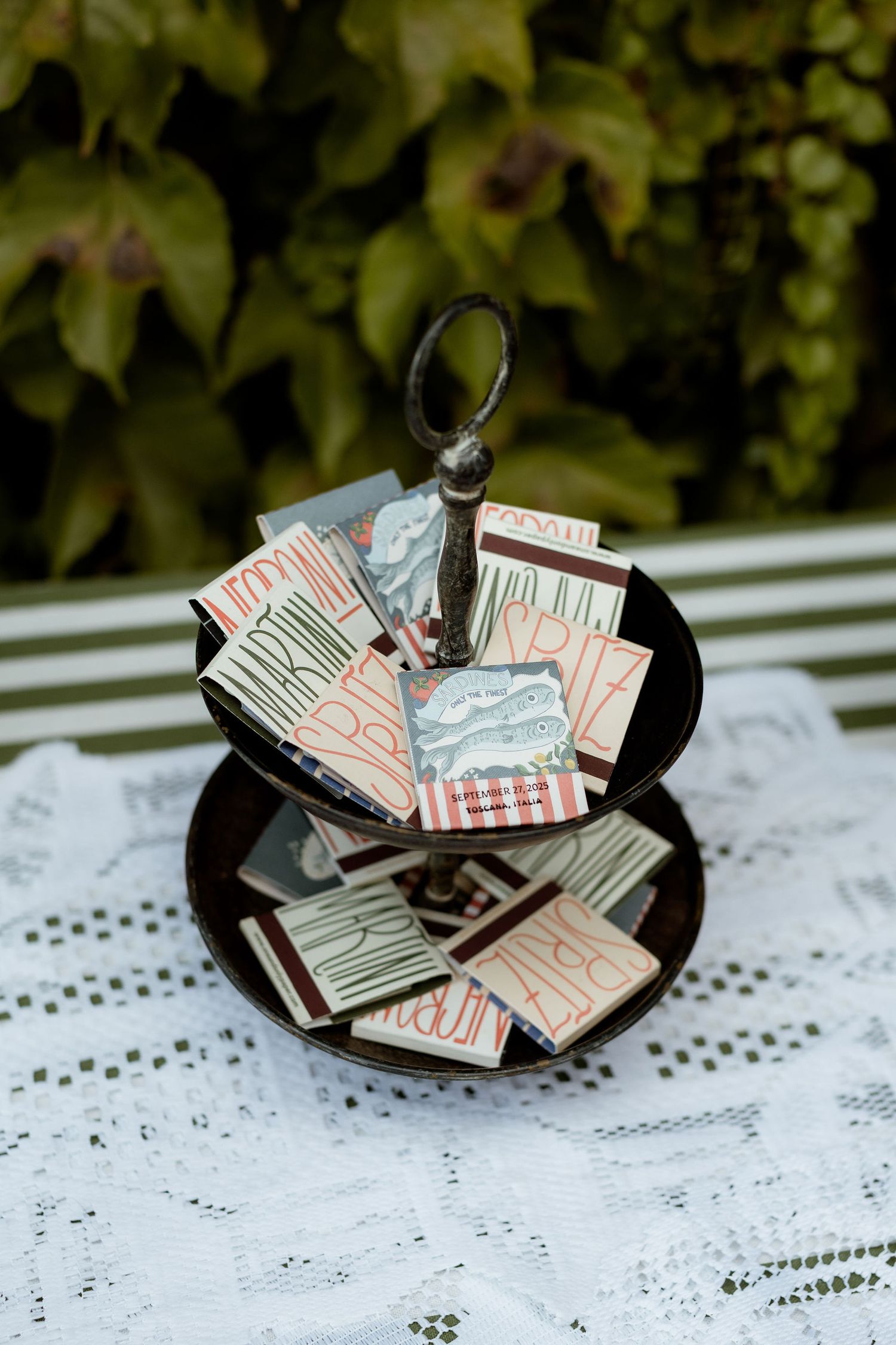 A sequence of three photos showing a handmade paper book ring with black band and folded pages on white lace.