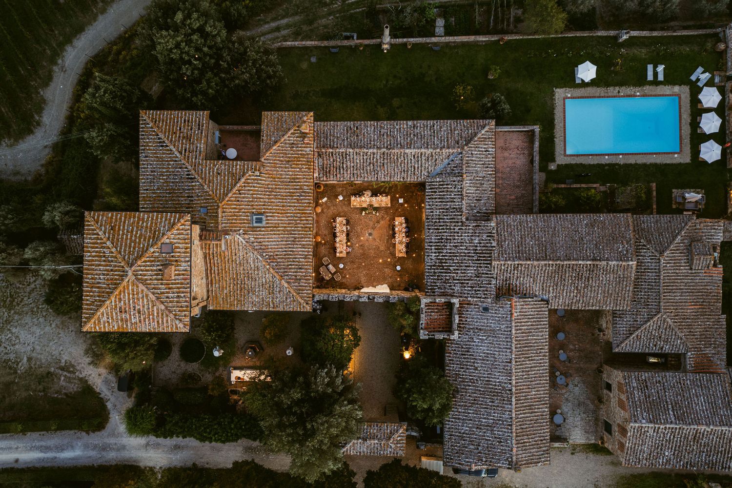 Aerial view of Mediterranean-style homes with terracotta tile roofs and landscaped yards in a residential neighborhood.