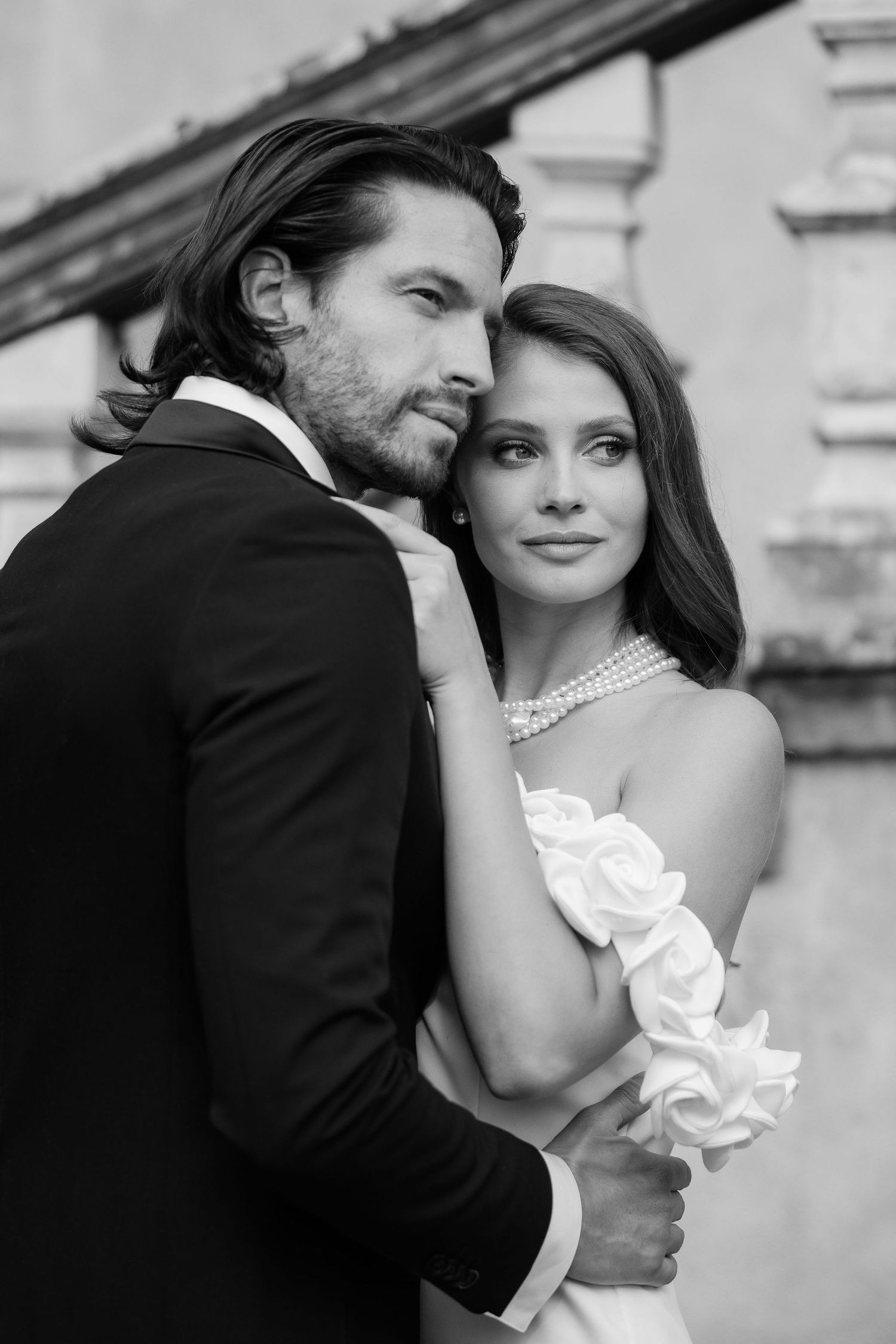 Romantic black and white wedding photos showing tender moments between newlyweds in elegant formal attire.