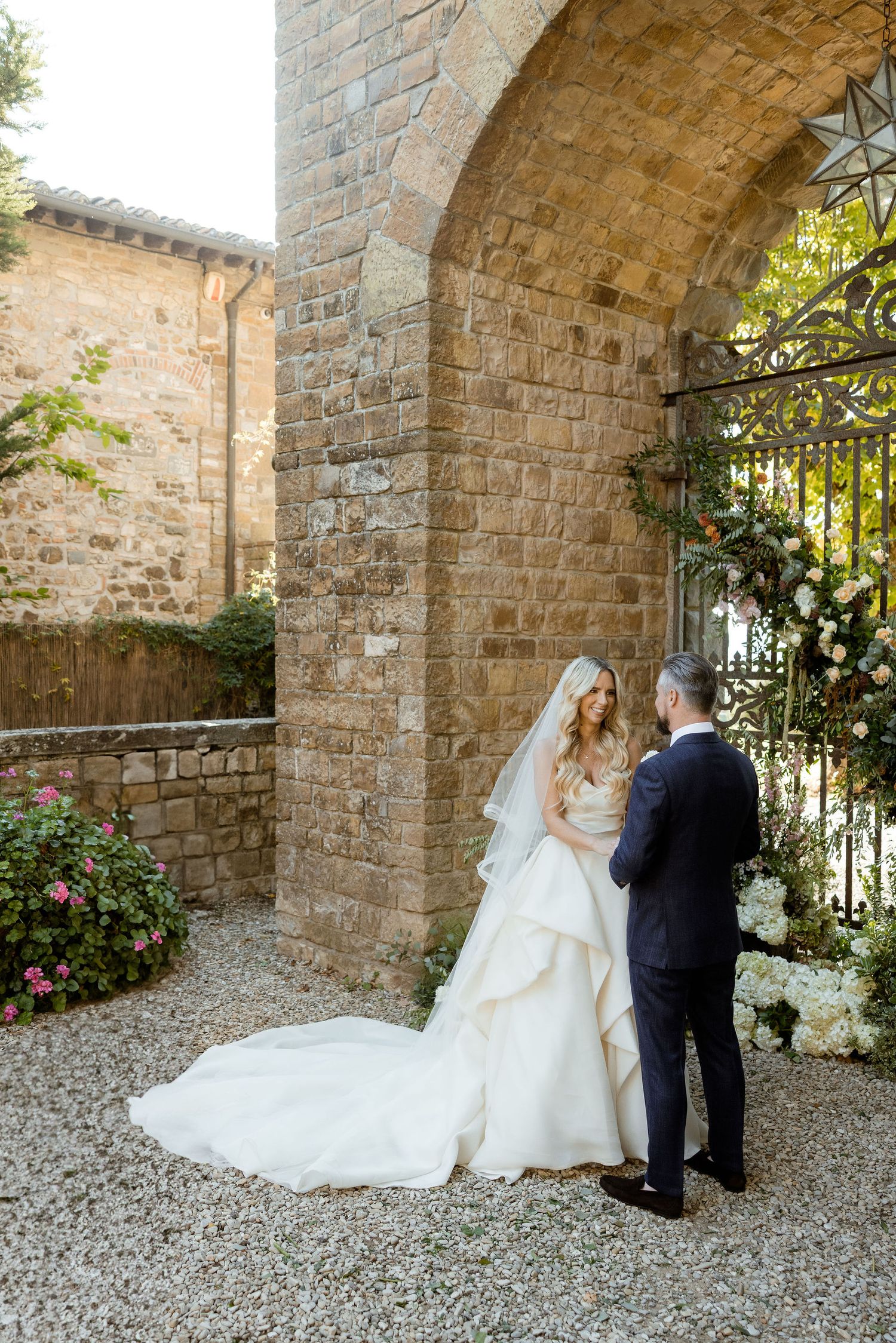 A romantic wedding moment captured in a sequence of photos against a rustic stone wall and gravel path.
