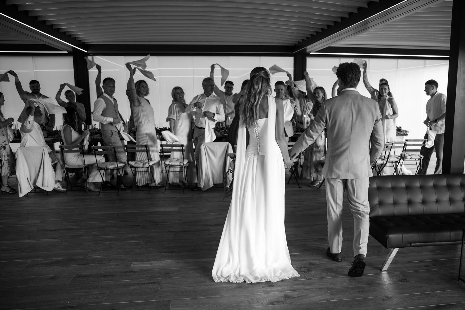 Wedding guests dance together on a crowded dance floor at a reception celebration.