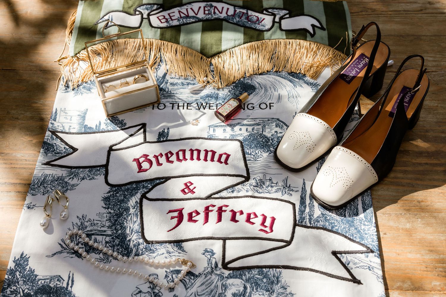 Wedding details including personalized banner, white shoes, and rustic decor laid out on wooden surface.