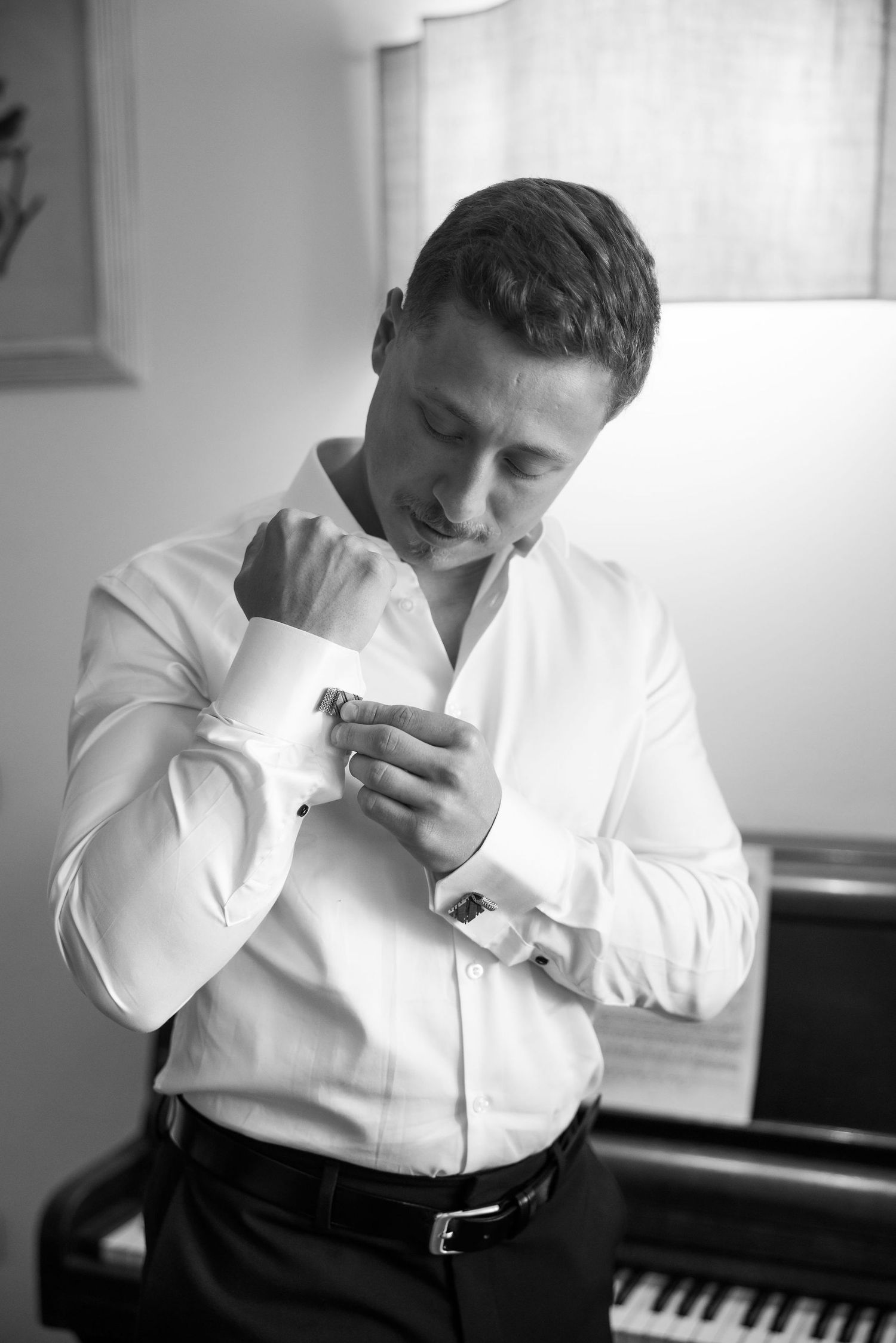 Black and white photo series showing a person in a white dress shirt sneezing into their elbow against a light background.