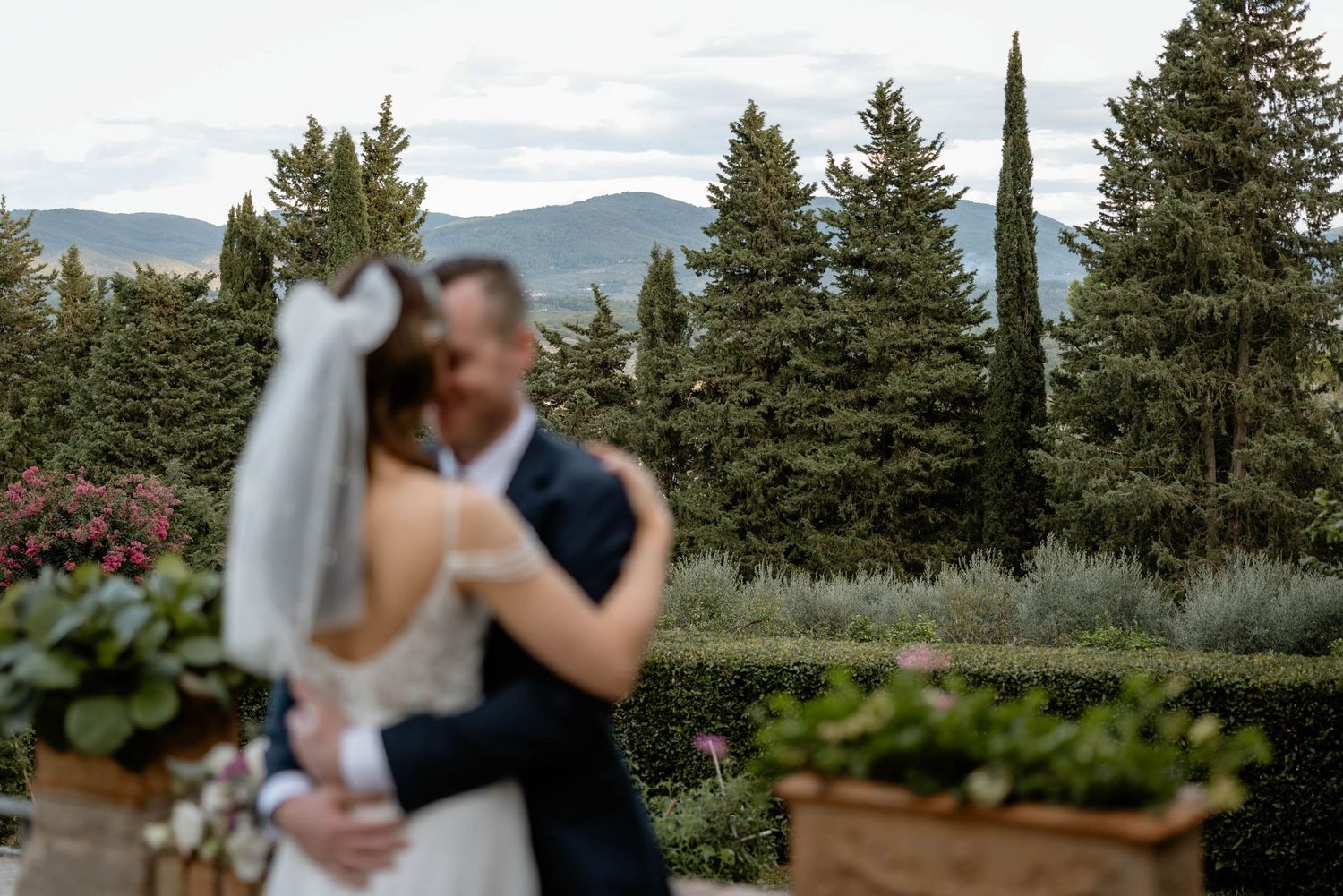 Intimate wedding moment with mountain landscape and garden setting.