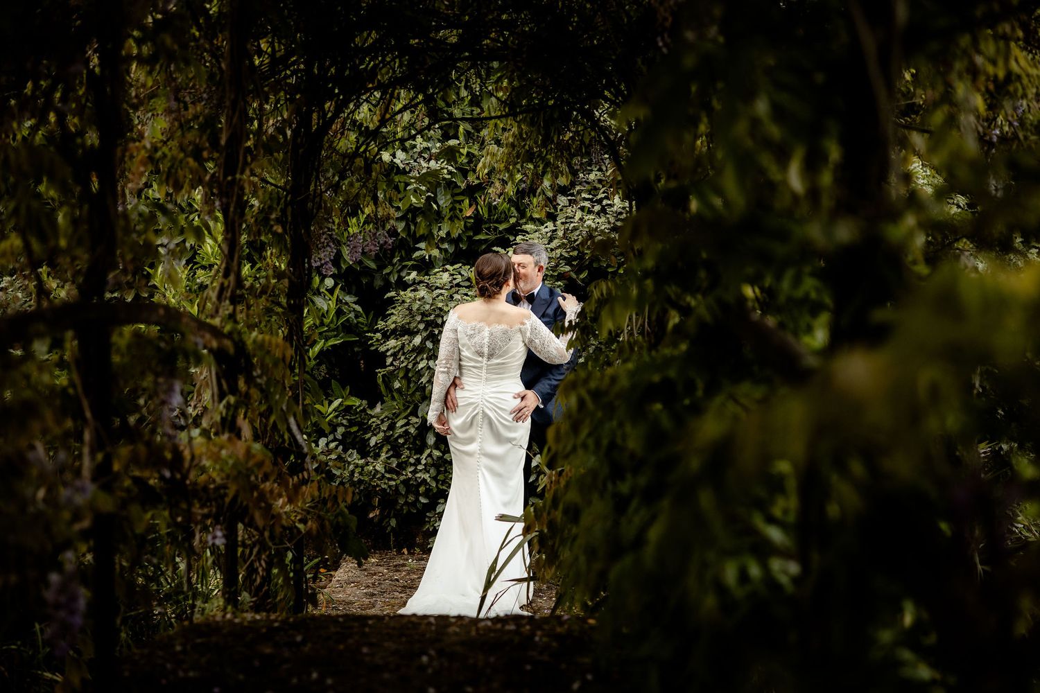 A series of romantic wedding photos in a lush garden setting with natural light filtering through the trees.