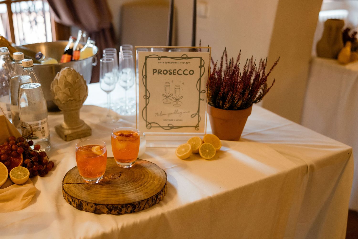 A rustic wedding reception table setting features wooden slices, glowing candles, and elegant place settings.
