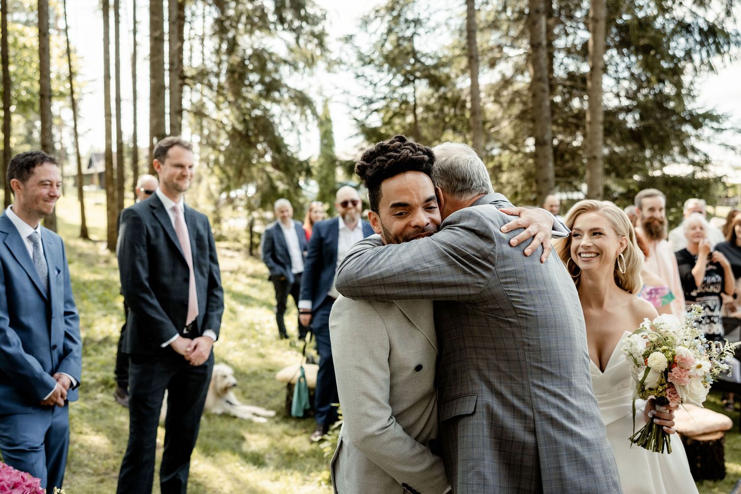 Emotional moment during forest wedding ceremony with guests watching.