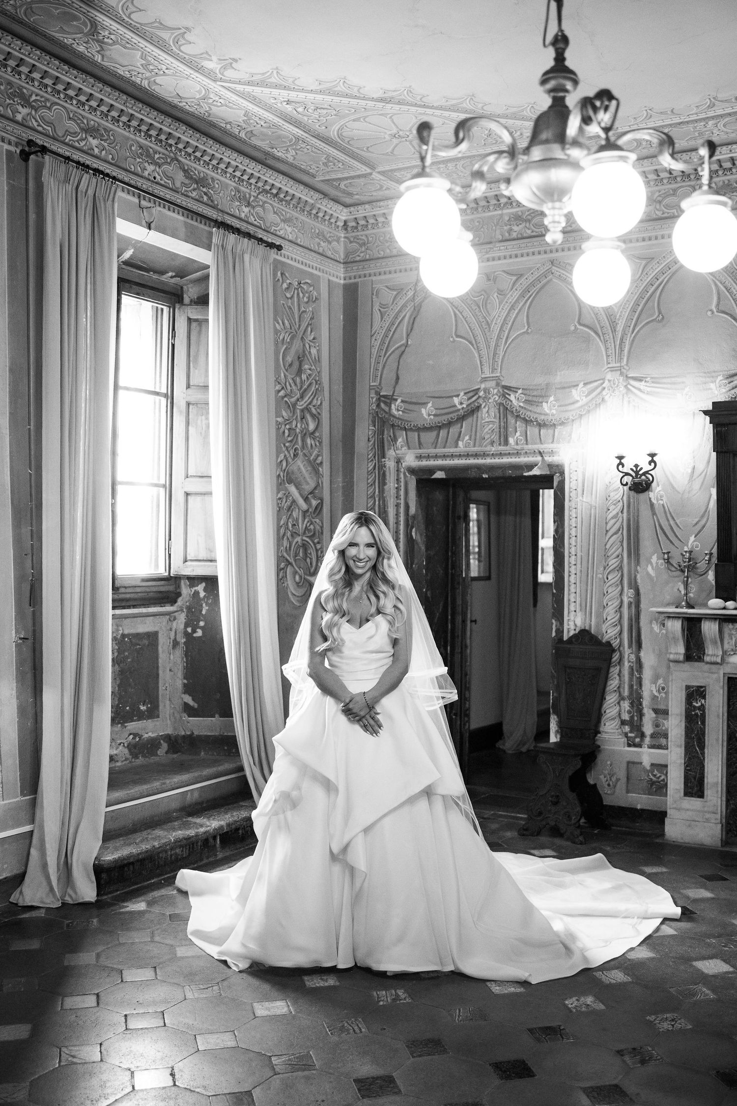 A black and white photo series showing a bride in a flowing white gown posing in an ornate vintage ballroom.
