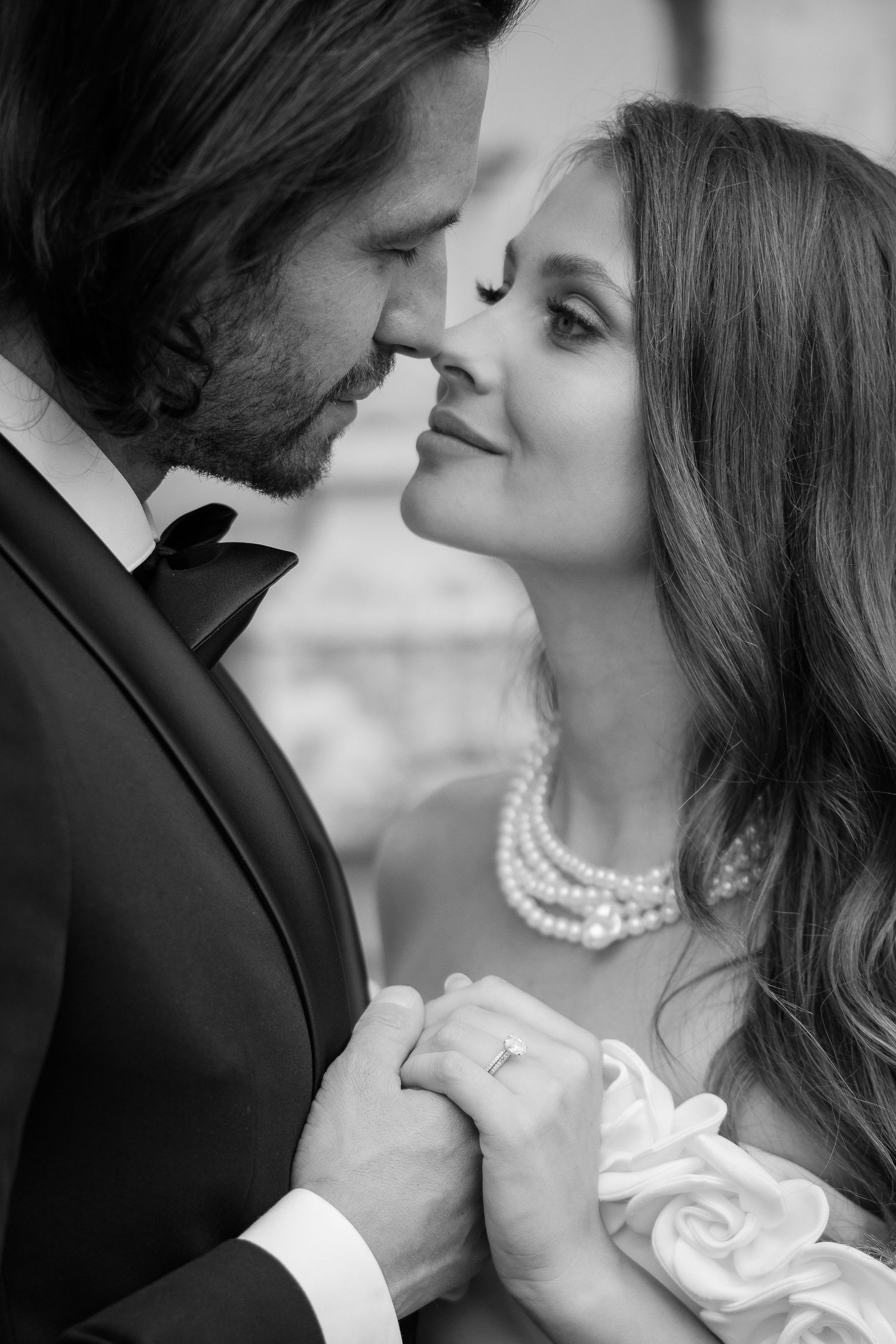 Black and white wedding portraits capturing intimate moments between a couple in classic formal wear.