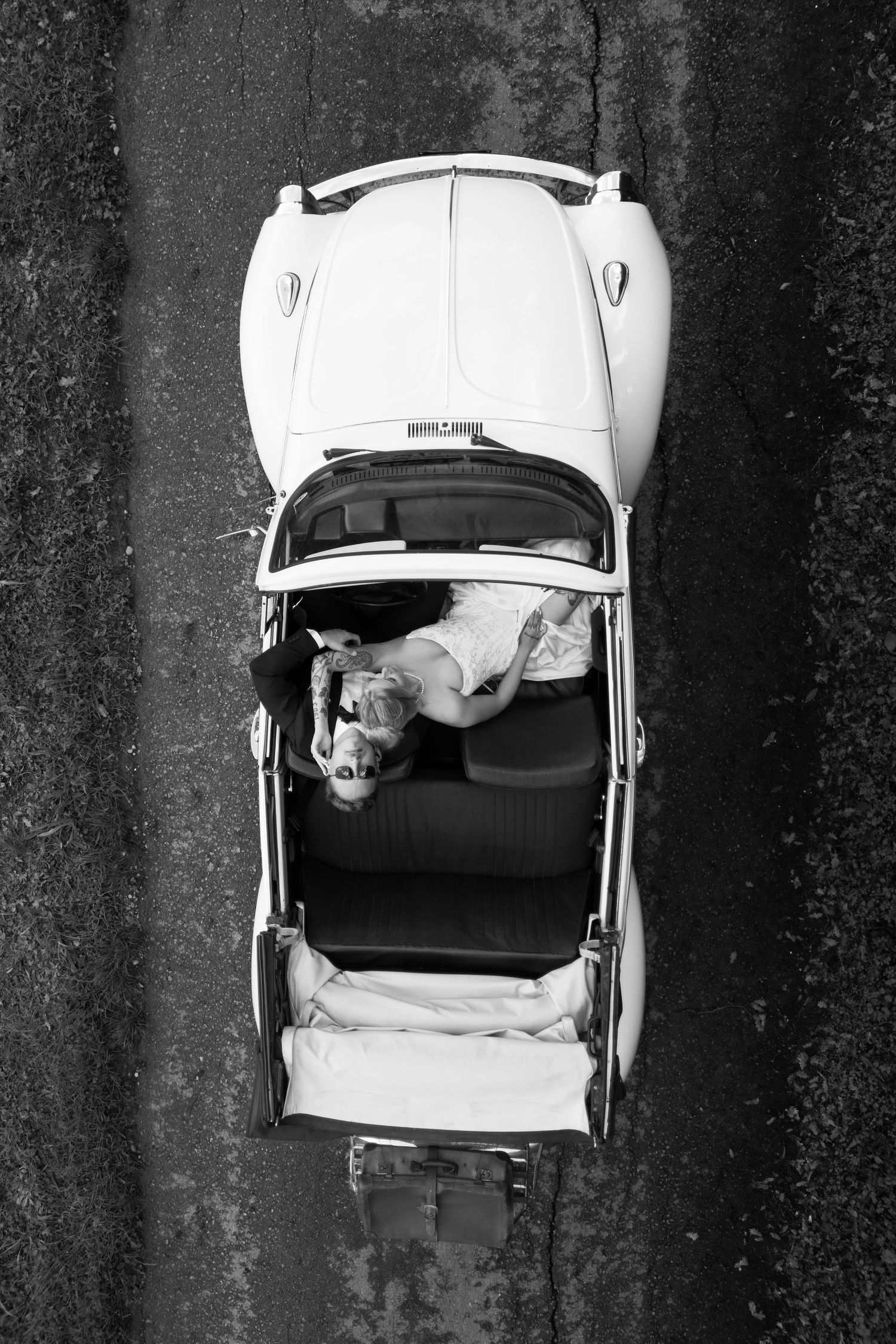 Aerial black and white photo sequence showing a white car with open trunk viewed from above against dark background.
