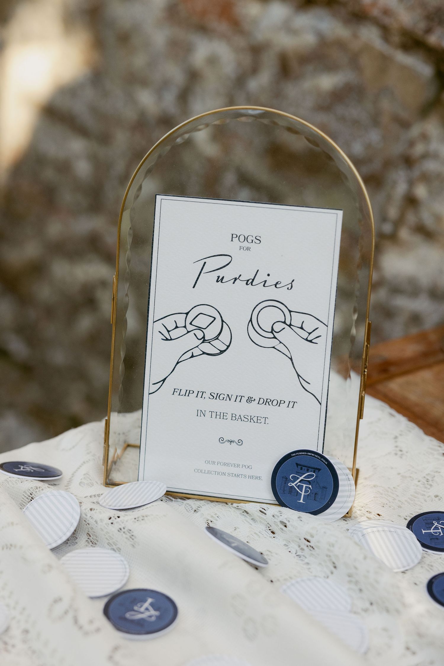 Wedding sign for party snacks displayed in a curved glass frame with blue wax seals on a white textured surface.