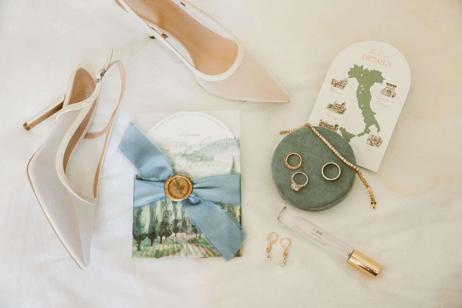 Delicate watercolor wedding stationery with sage green accents and romantic calligraphy displayed on a cream background.