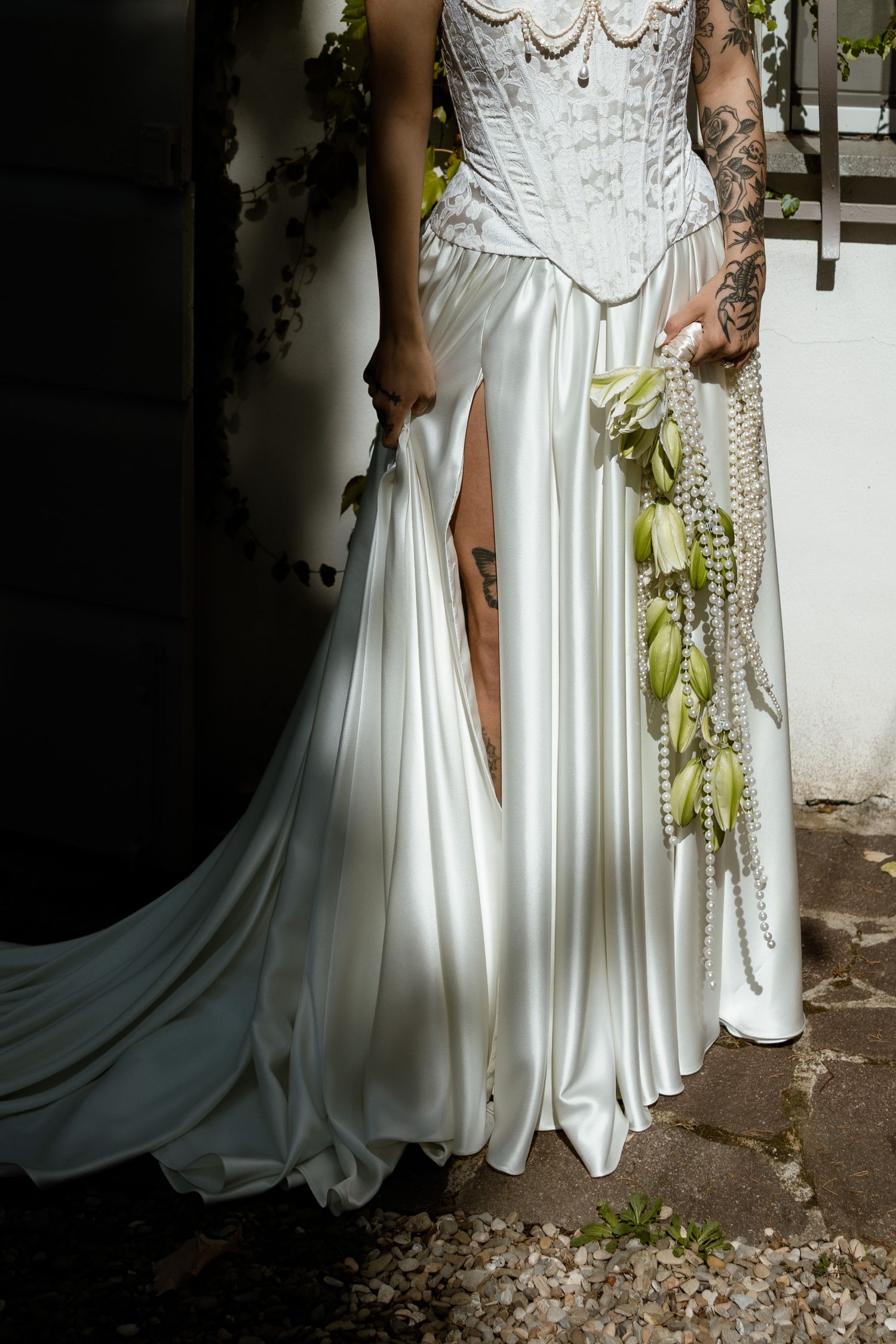 Two wedding dresses shown side by side with flowing white fabric and elegant details in an outdoor garden setting.