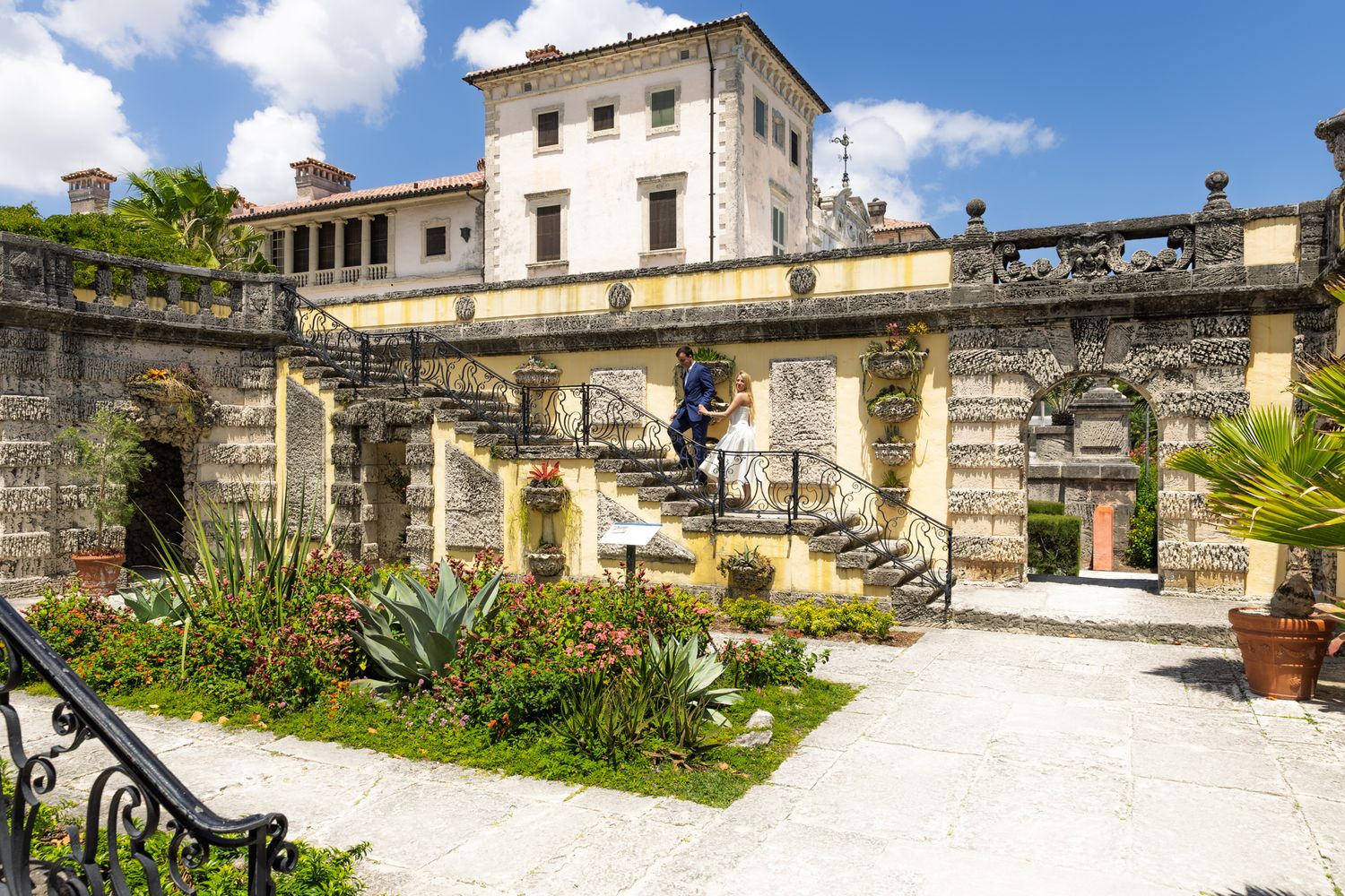 Historic Italian villa Vizcaya in Miami features ornate stone archways and manicured gardens with tropical landscaping.