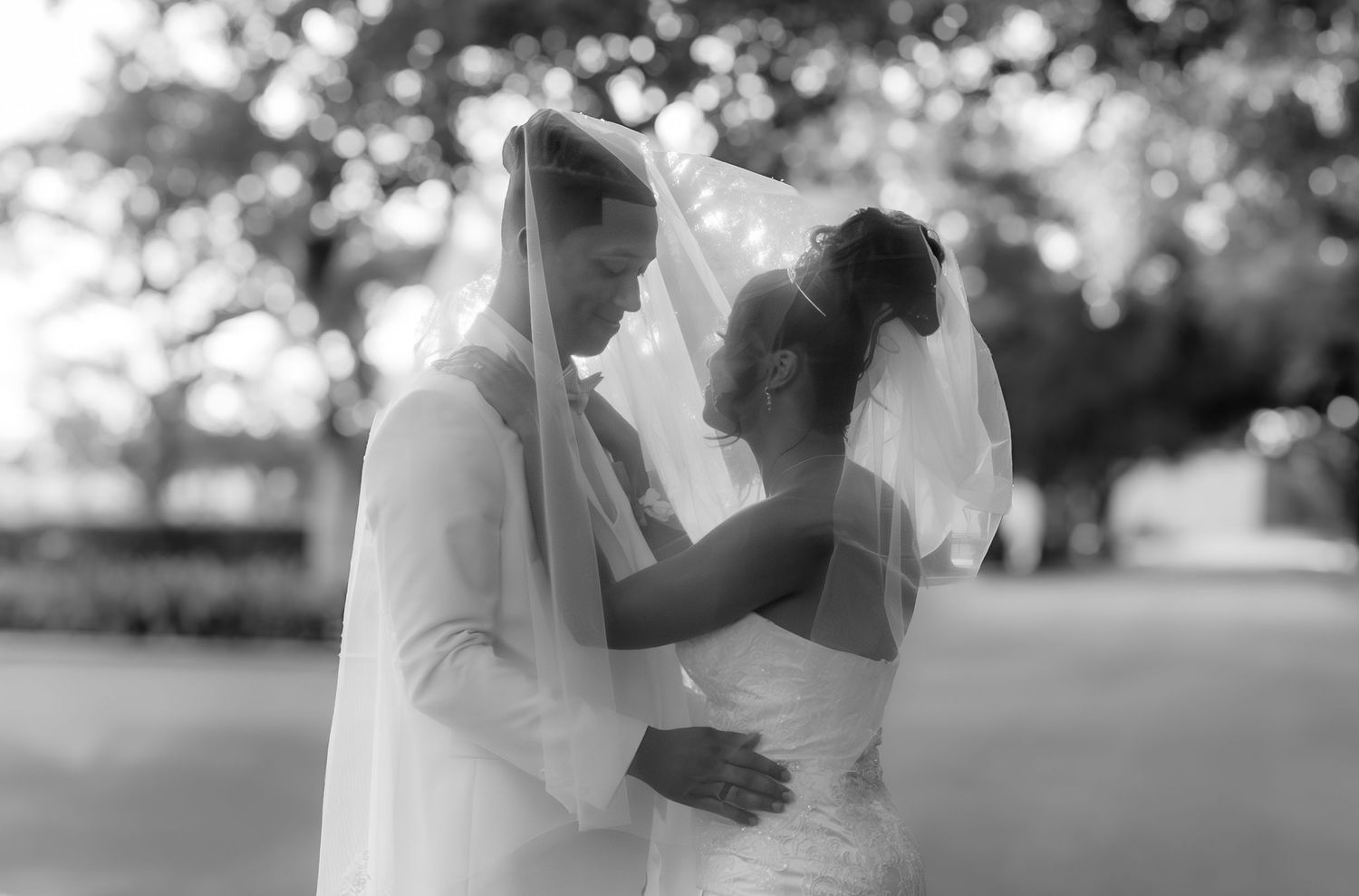 A romantic wedding couple sharing an intimate moment under a veil.