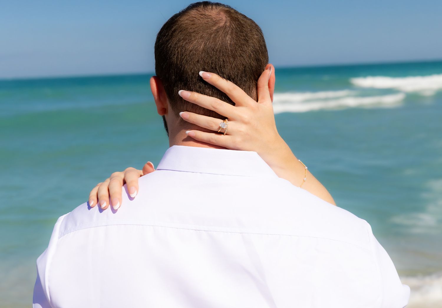 A gentle touch captured against the backdrop of rolling ocean waves.