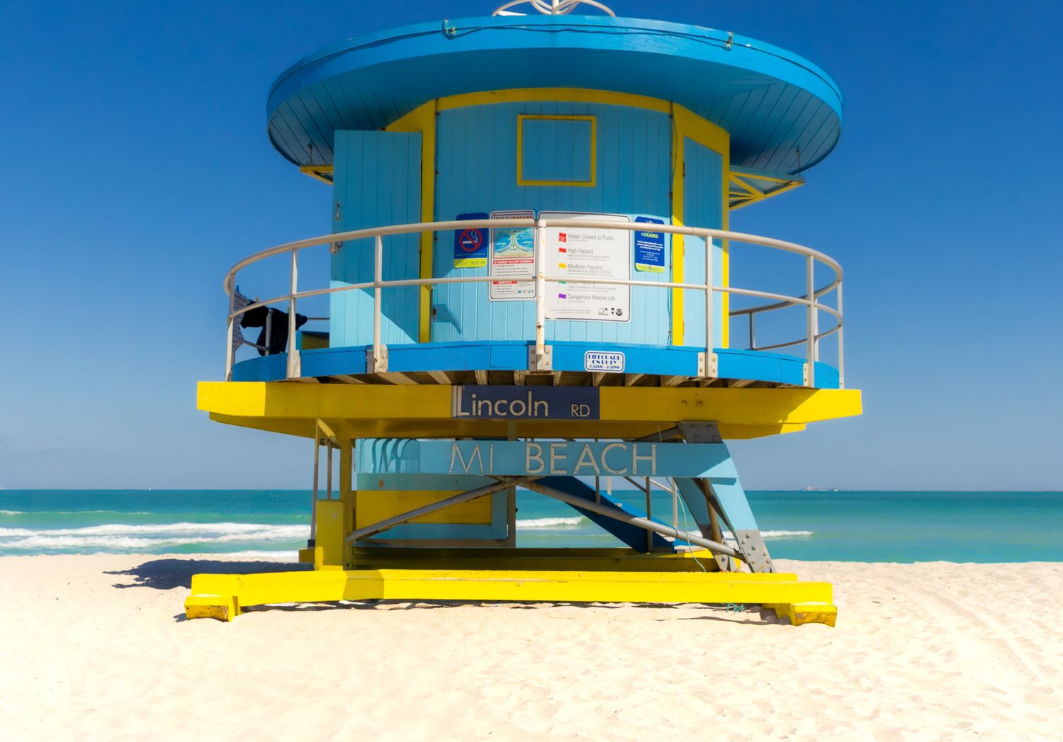 A bright blue and yellow Art Deco style lifeguard tower stands on Miami Beach.