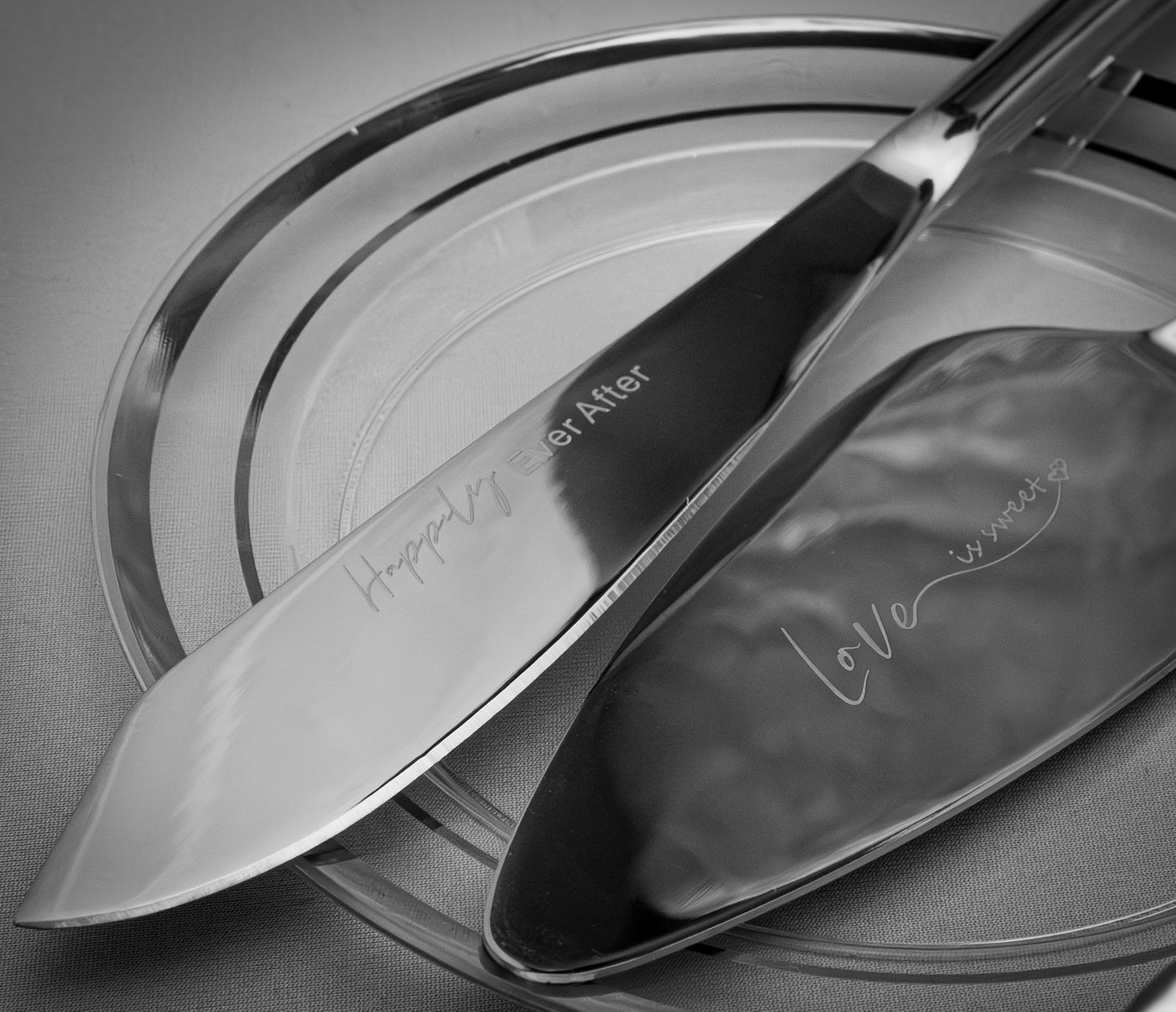 Close-up of shiny wedding cake serving utensils in black and white.