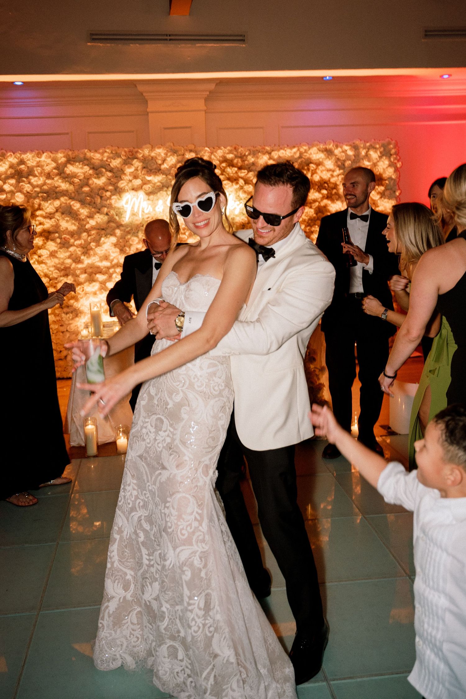 Wedding celebration on dance floor with guests dancing and enjoying the festivities.