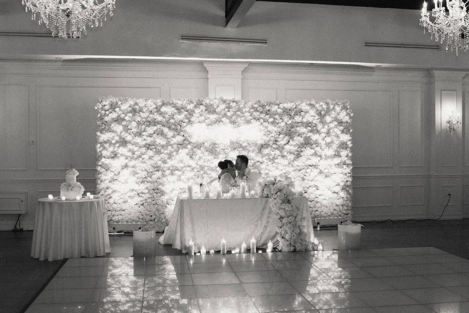 Wedding venue decorated with dramatic chandeliers and soft lighting creating a romantic atmosphere.
