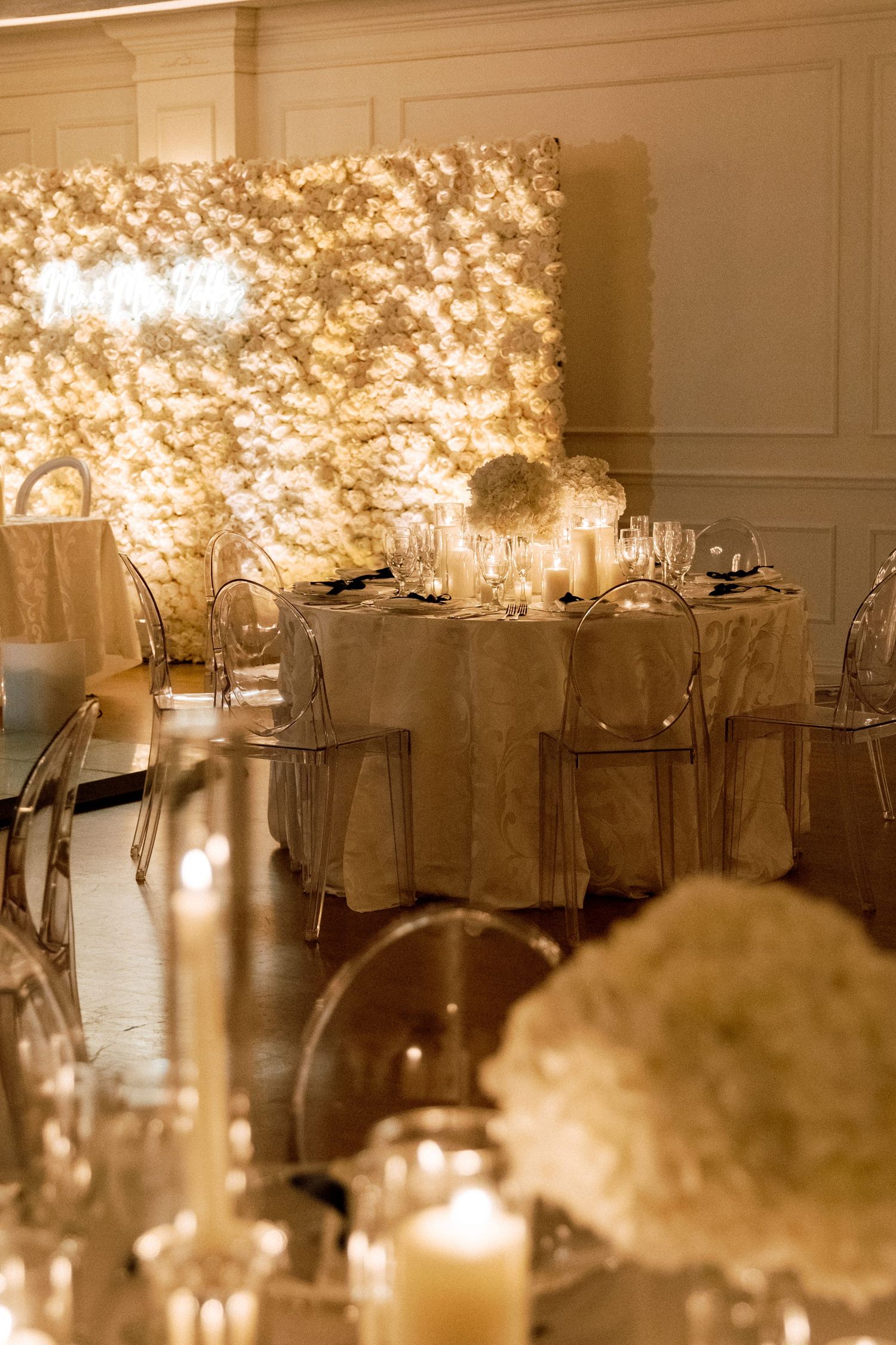 Elegant wedding reception table settings with soft lighting and floral centerpieces.