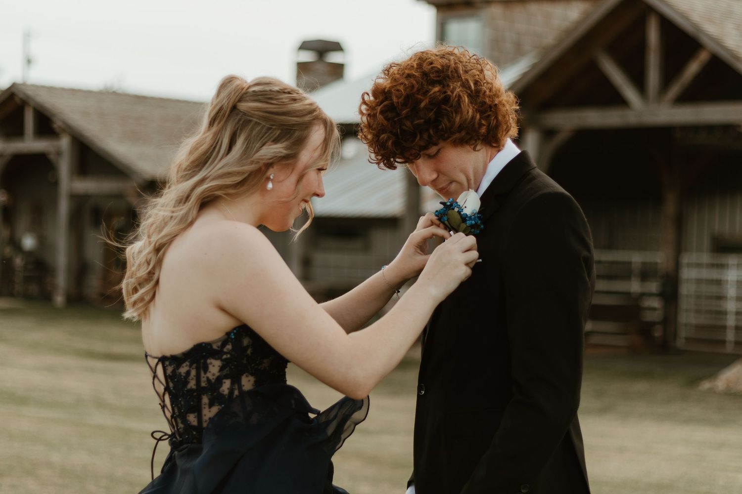A tender moment as someone adjusts a blue boutonniere on formal attire at a venue in Northeast Georgia.
