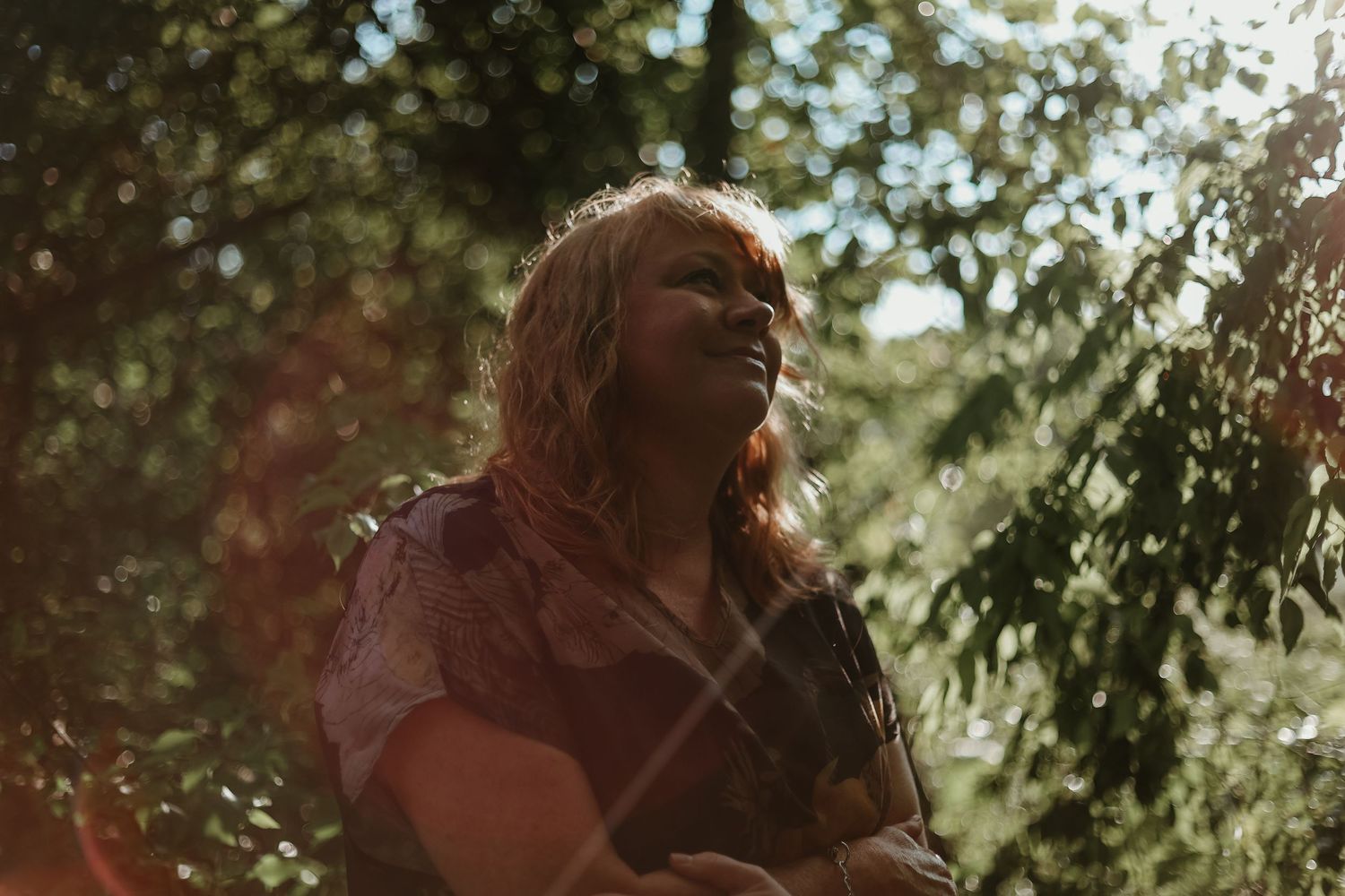 A figure enjoying golden sunlight through tree branches in a dreamy outdoor setting near Hartwell, GA.
