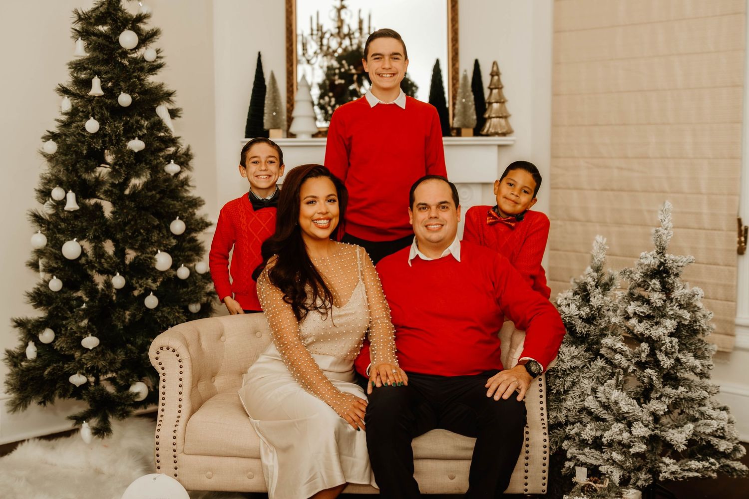 Holiday family portraits with decorated Christmas trees and festive decor in background at South Elm Events in Commerce.