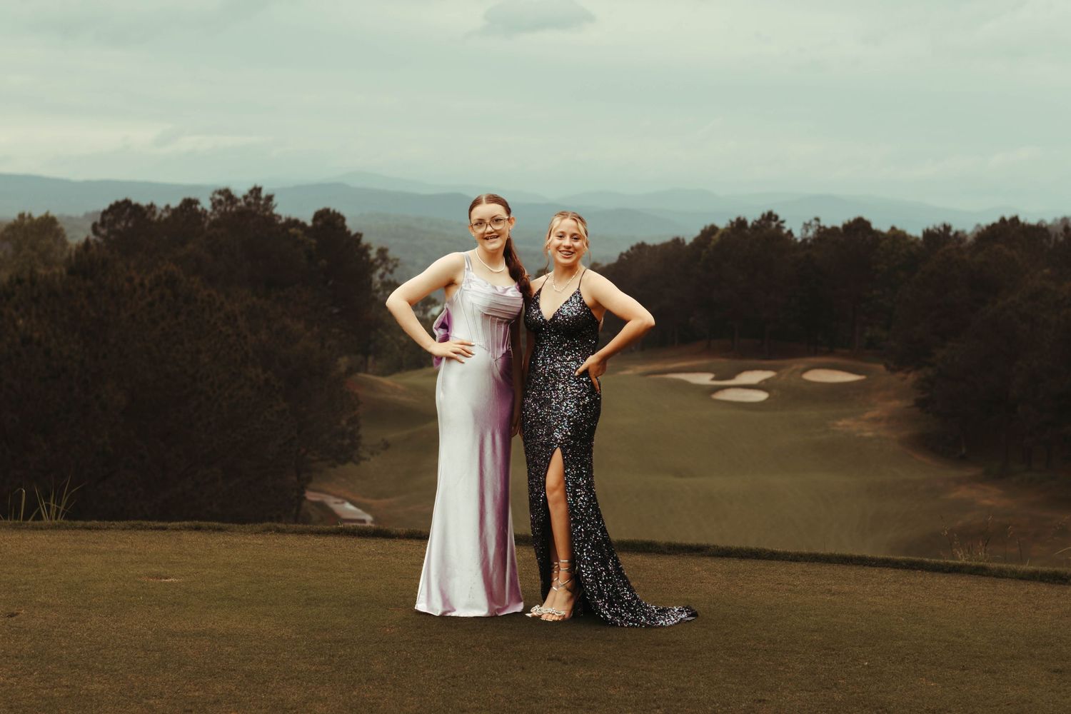 Two people in formal attire embrace on a scenic hilltop during golden hour at Currahee Club in Toccoa, Georgia.
