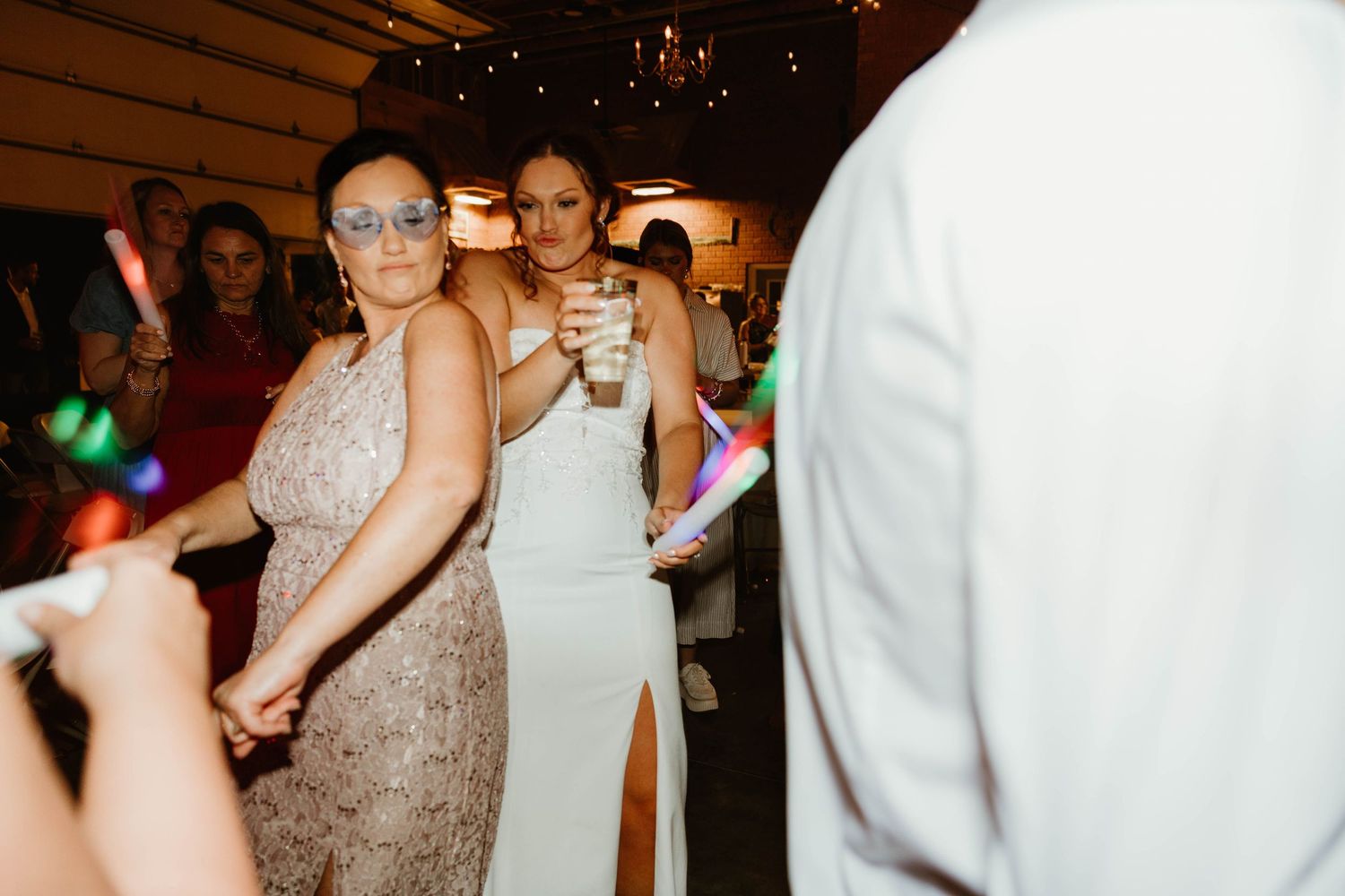 Party guests enjoying themselves on a dance floor with festive lighting and decorations.