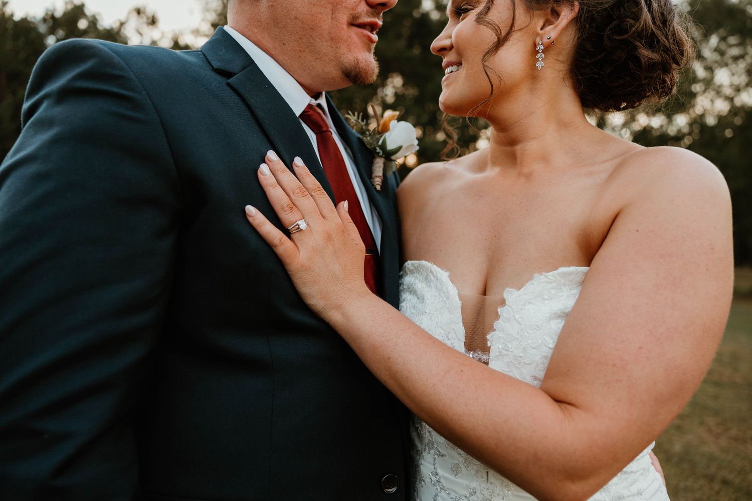 Romantic outdoor wedding scene showing tender moments between a couple in formal attire at sunset.