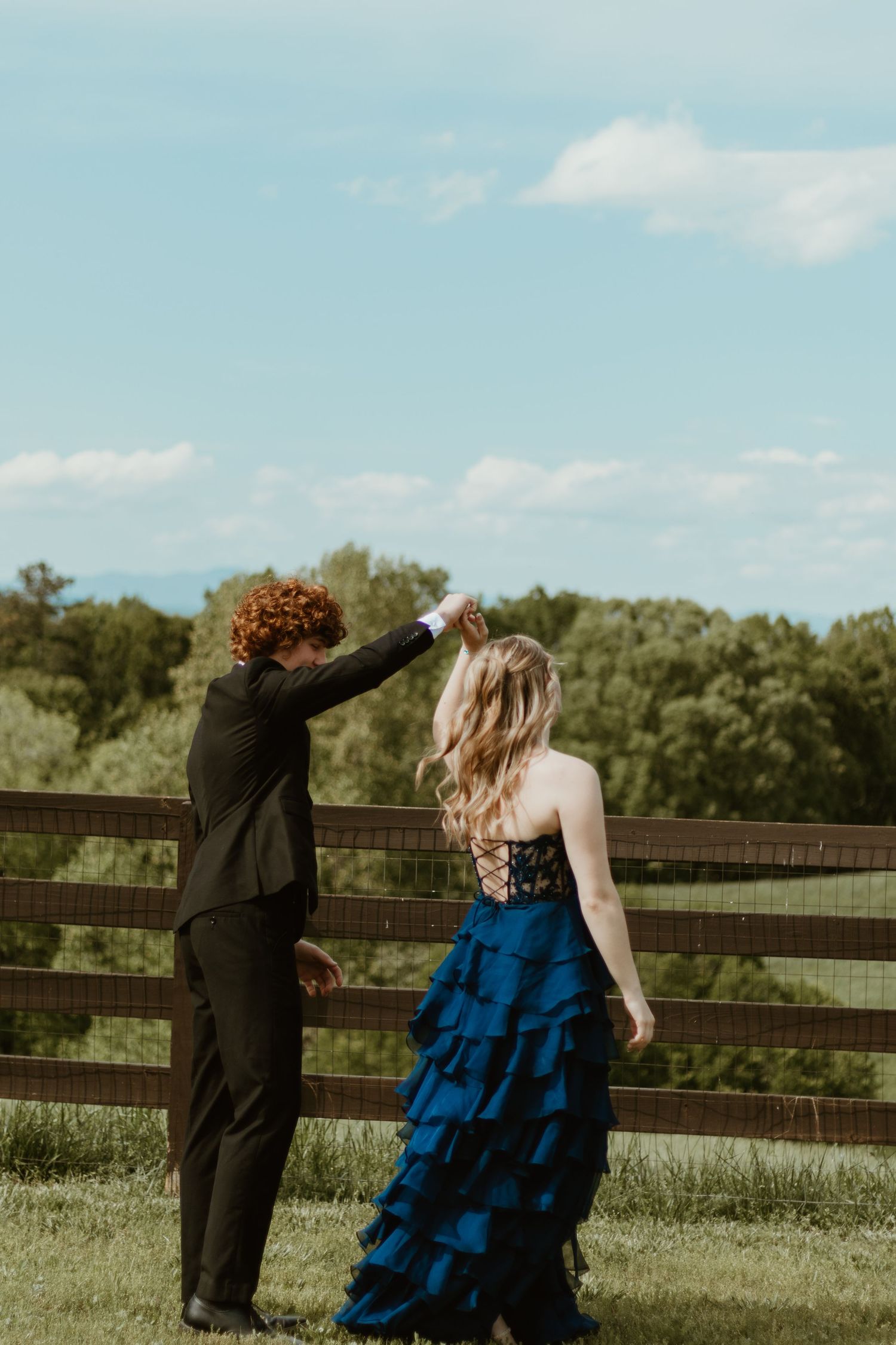 A dancing couple in formal wear spins near a wooden fence at sunset in Toccoa, GA.
