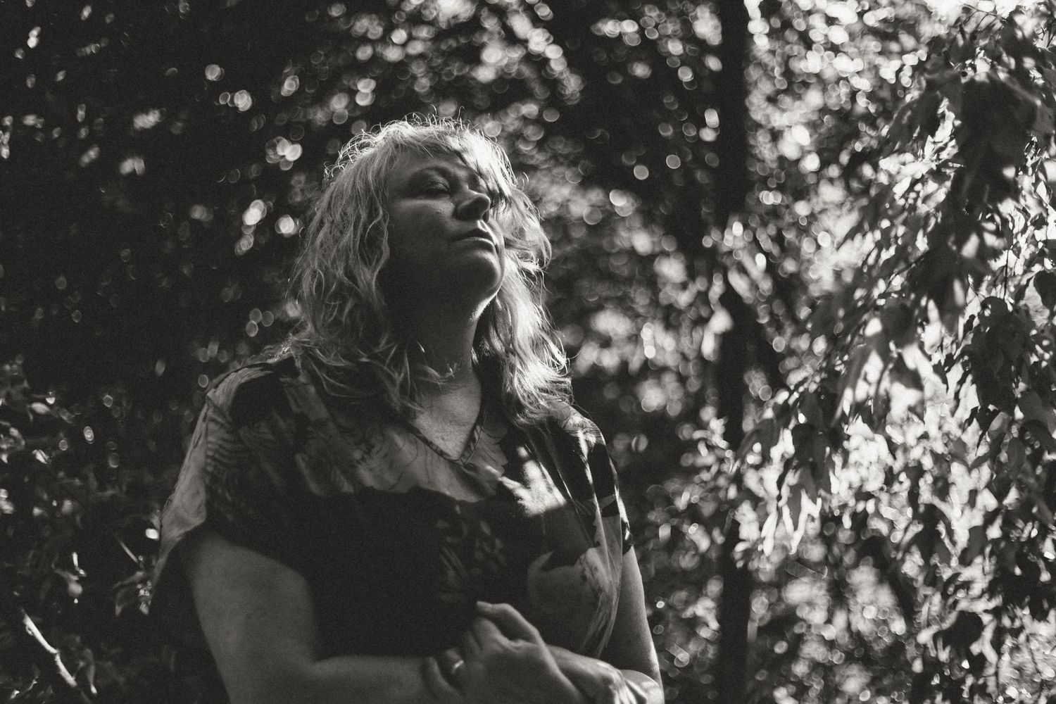 Dramatic black and white portrait through leaves creating natural light patterns near Clarkesville, Georgia.
