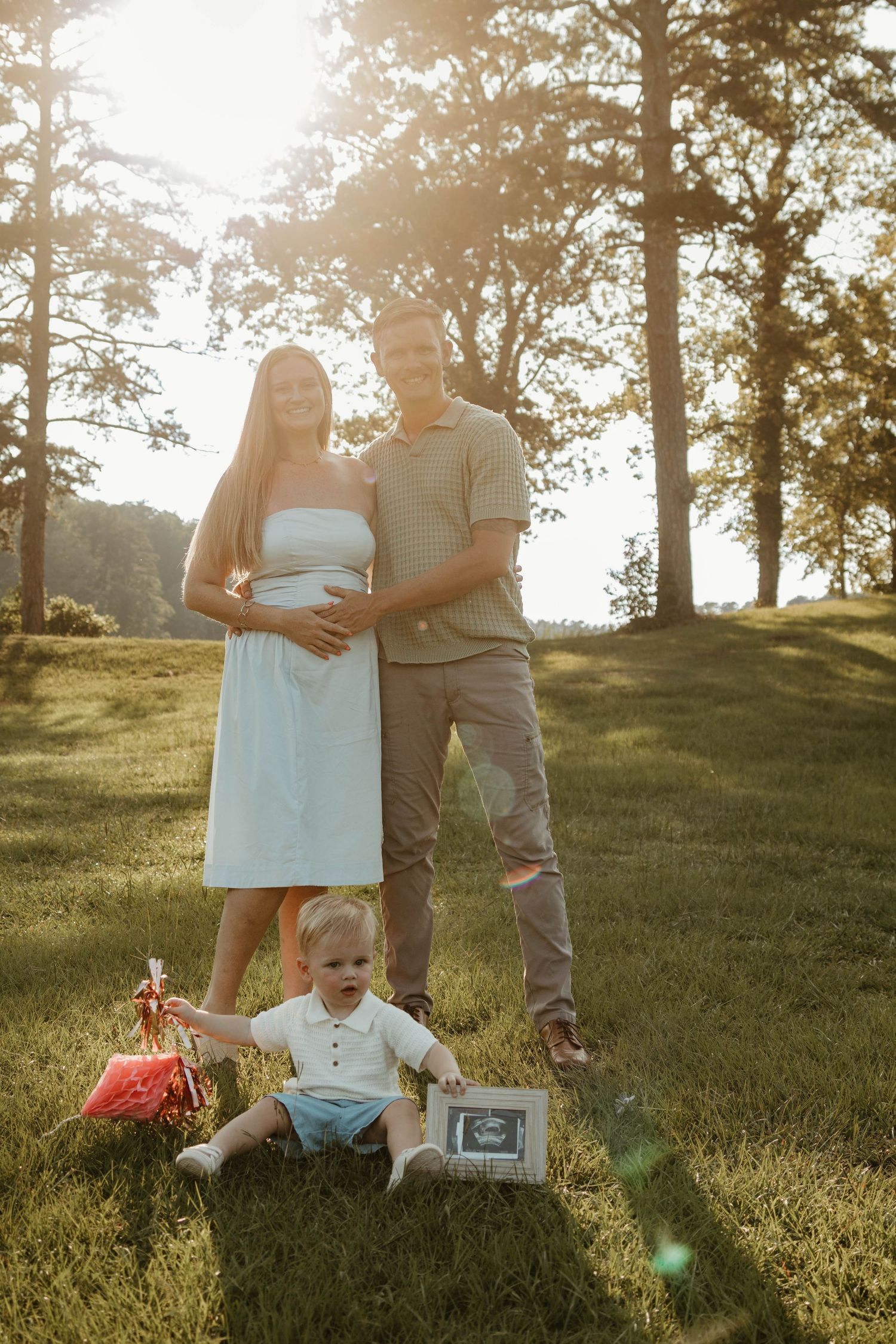 Sunset maternity photo in a wooded setting with ultrasound image prop at Lake Toccoa in Northeast Georgia.