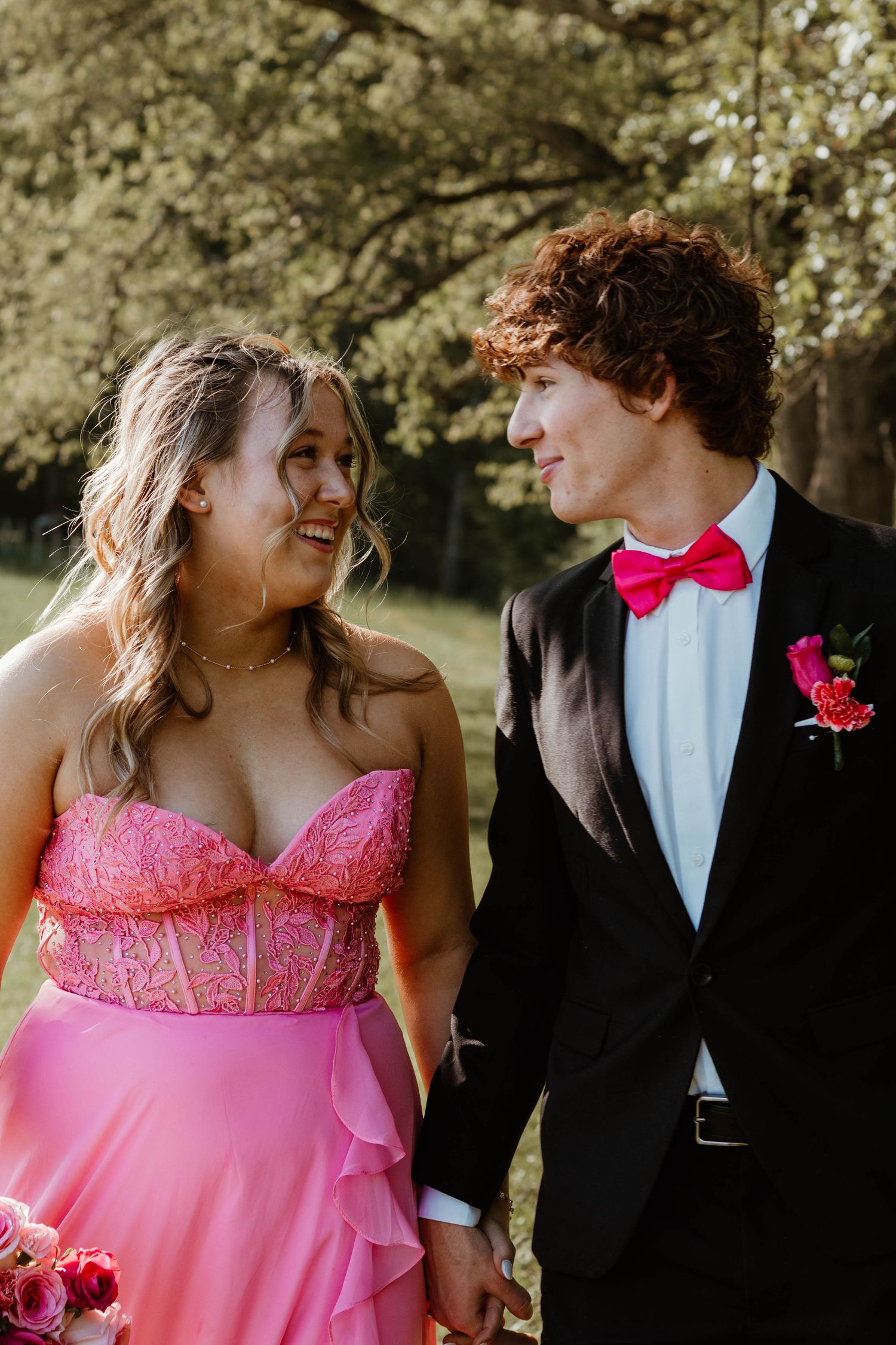 Spring outdoor portraits featuring pink formal dress and black tuxedo under blooming trees at The Farm at Daffodil Hill in northeast Georgia
