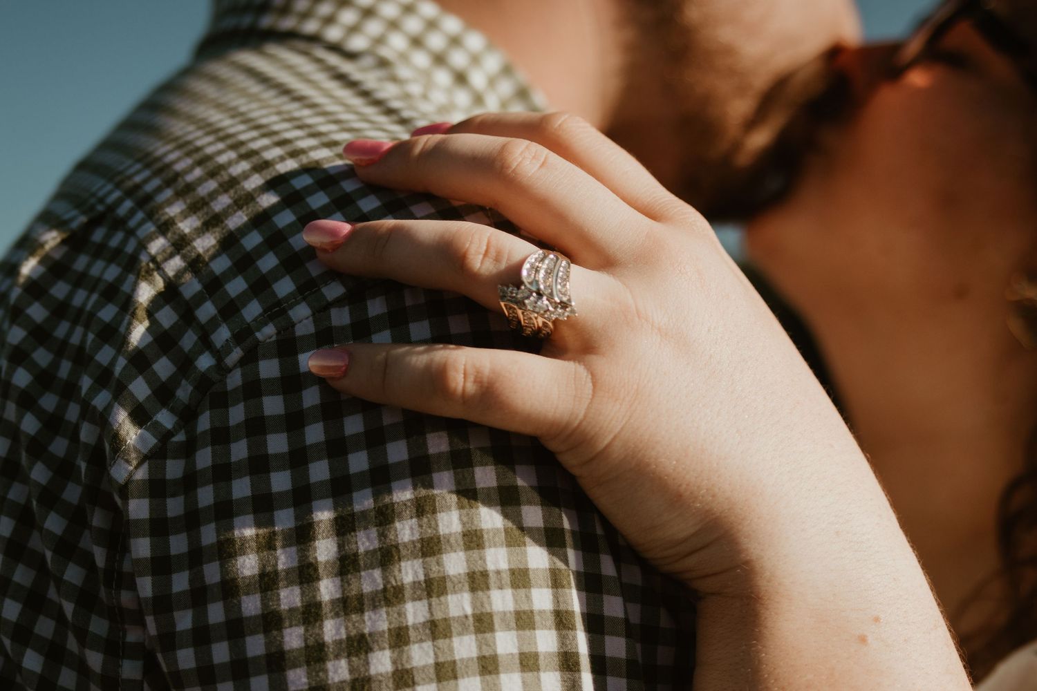 Two lovers in plaid shirts hold hands and embrace in a series of intimate close-up shots showing tender gestures.