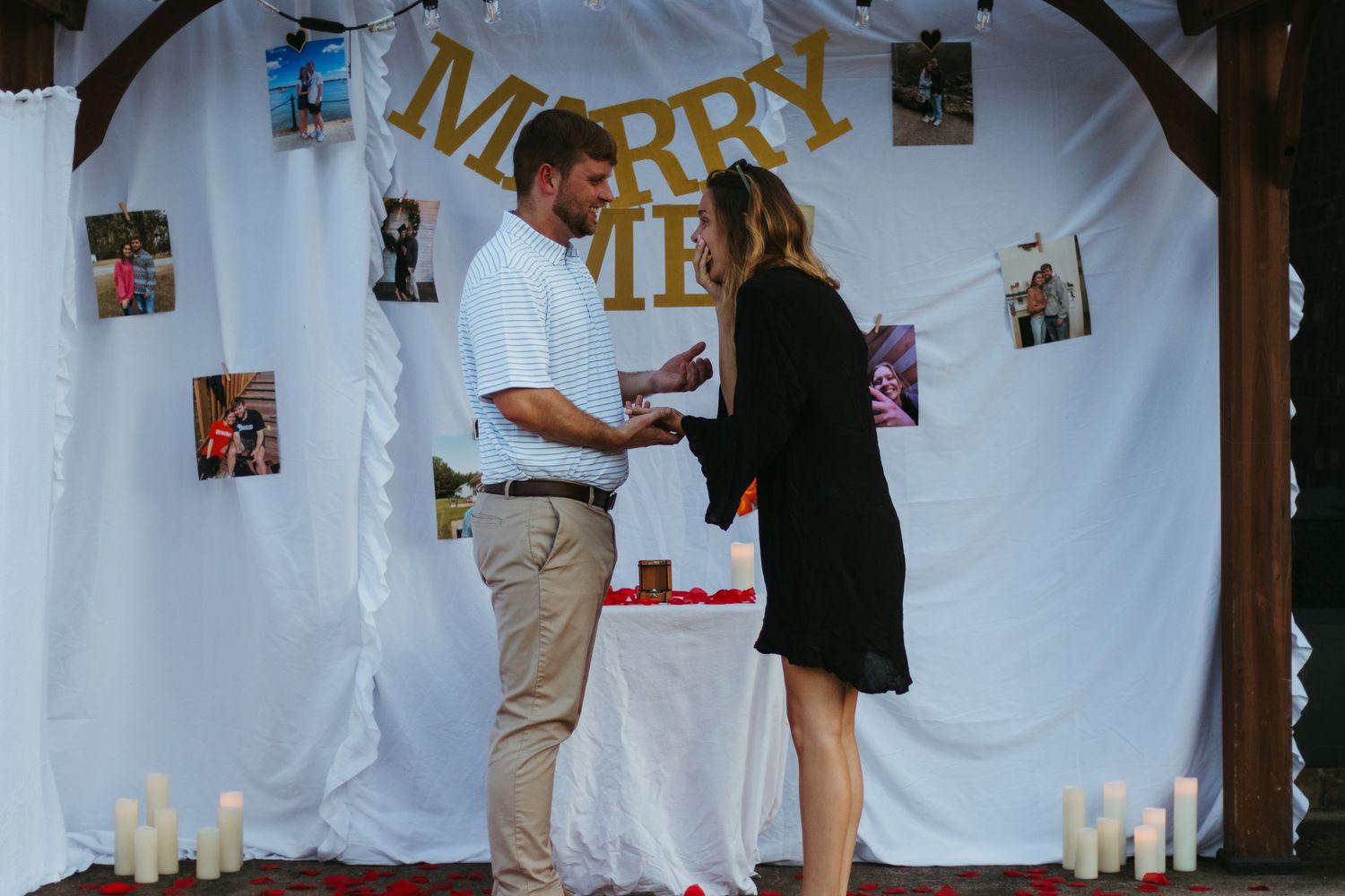 A long banner with paper decorations and photos hangs on a white wall during a celebration event.