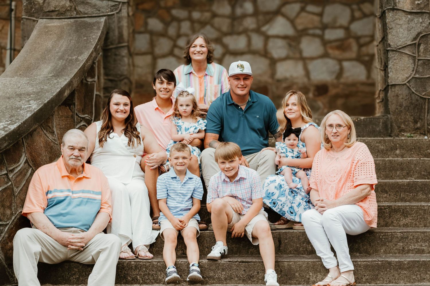 Family group poses together on stone steps for a casual outdoor photo session in Cornelia, Georgia.