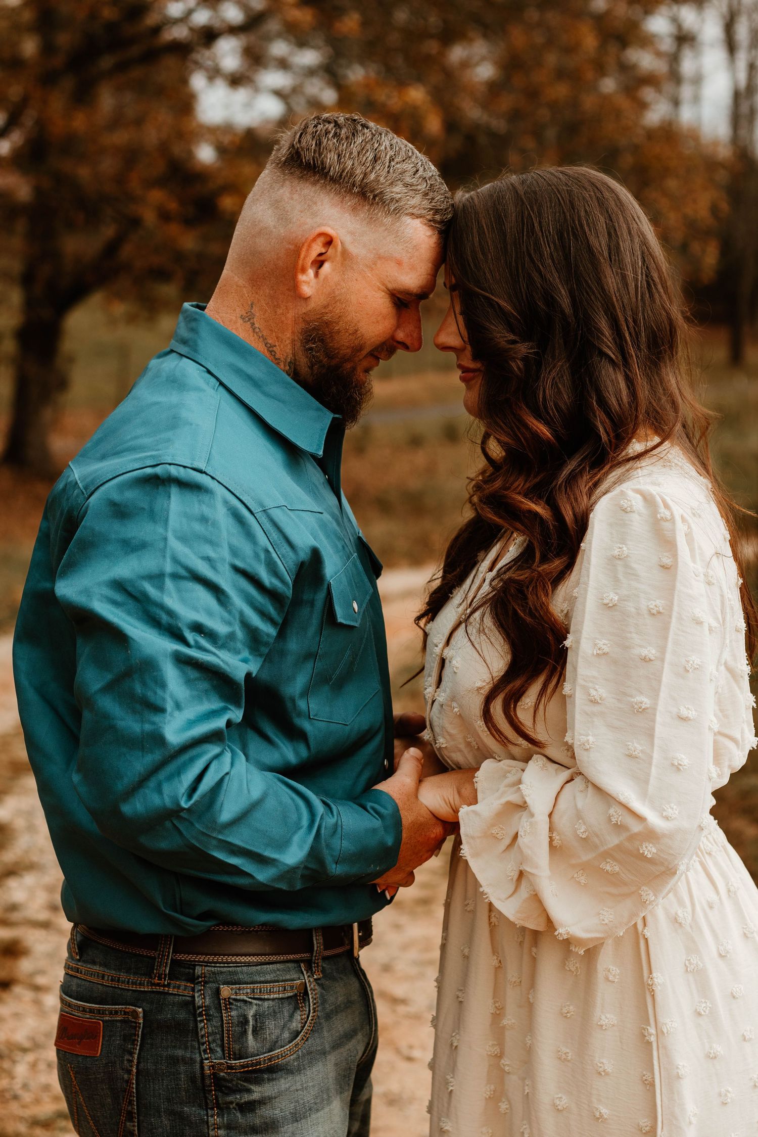 Romantic autumn couple photoshoot with intimate moments in teal and white outfits located at The Farm at Daffodil Hill in Georgia.