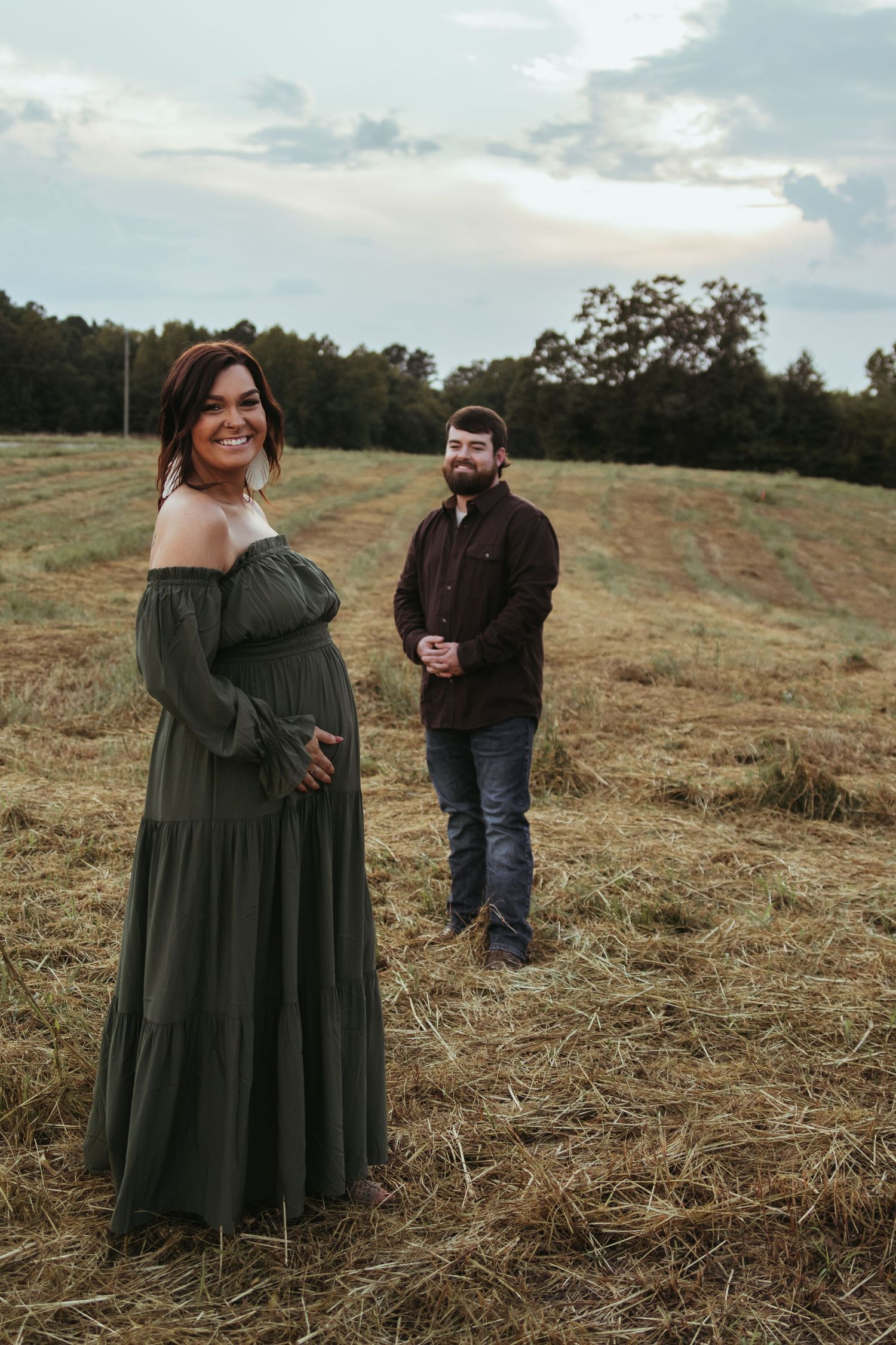 A couple sharing a special moment in a rustic field during golden hour maternity photoshoot in Toccoa, GA.