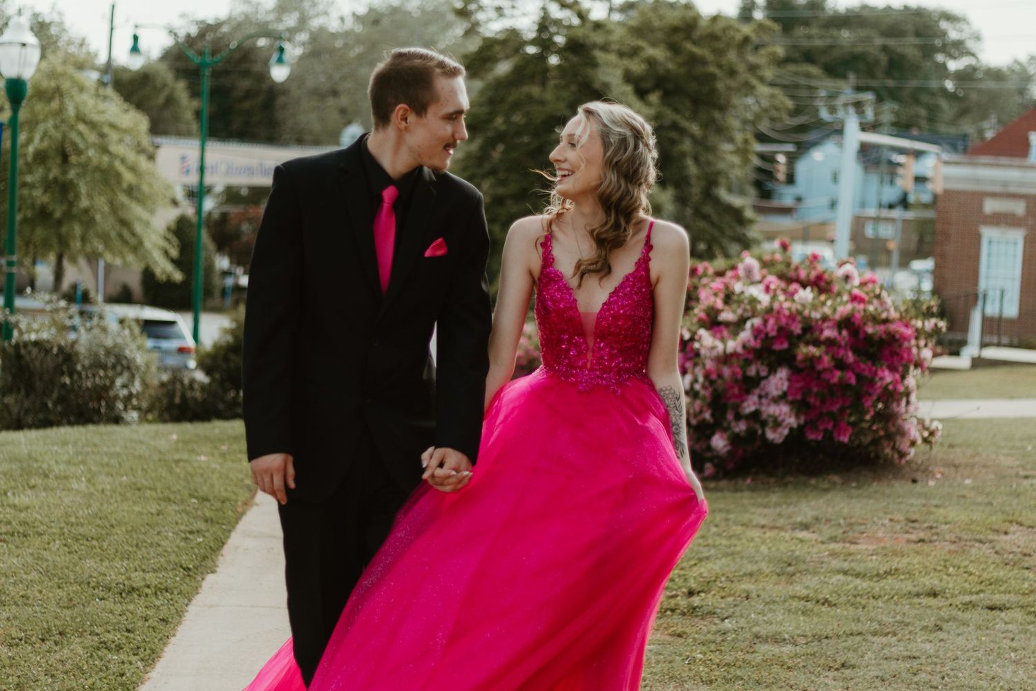 A vibrant pink ballgown flows in the breeze as a couple shares a sweet moment outdoors in Toccoa, GA.