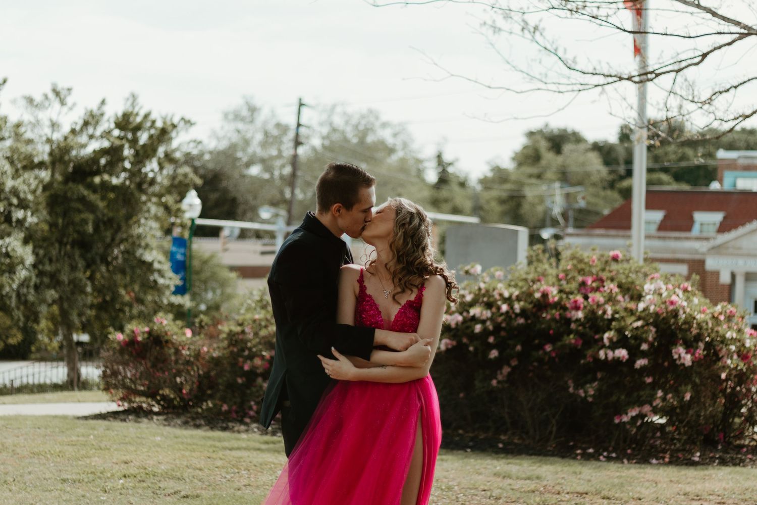 A romantic dance pose between two people in formal wear near blooming spring flowers in northeast GA.