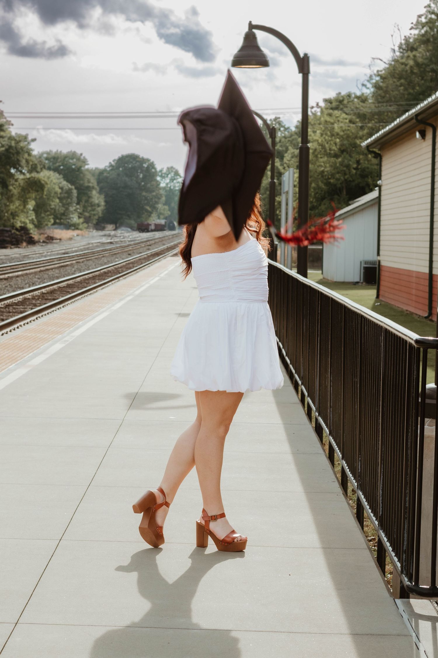 Person walking on a concrete platform near railroad tracks on a cloudy day near Athens, Georgia.